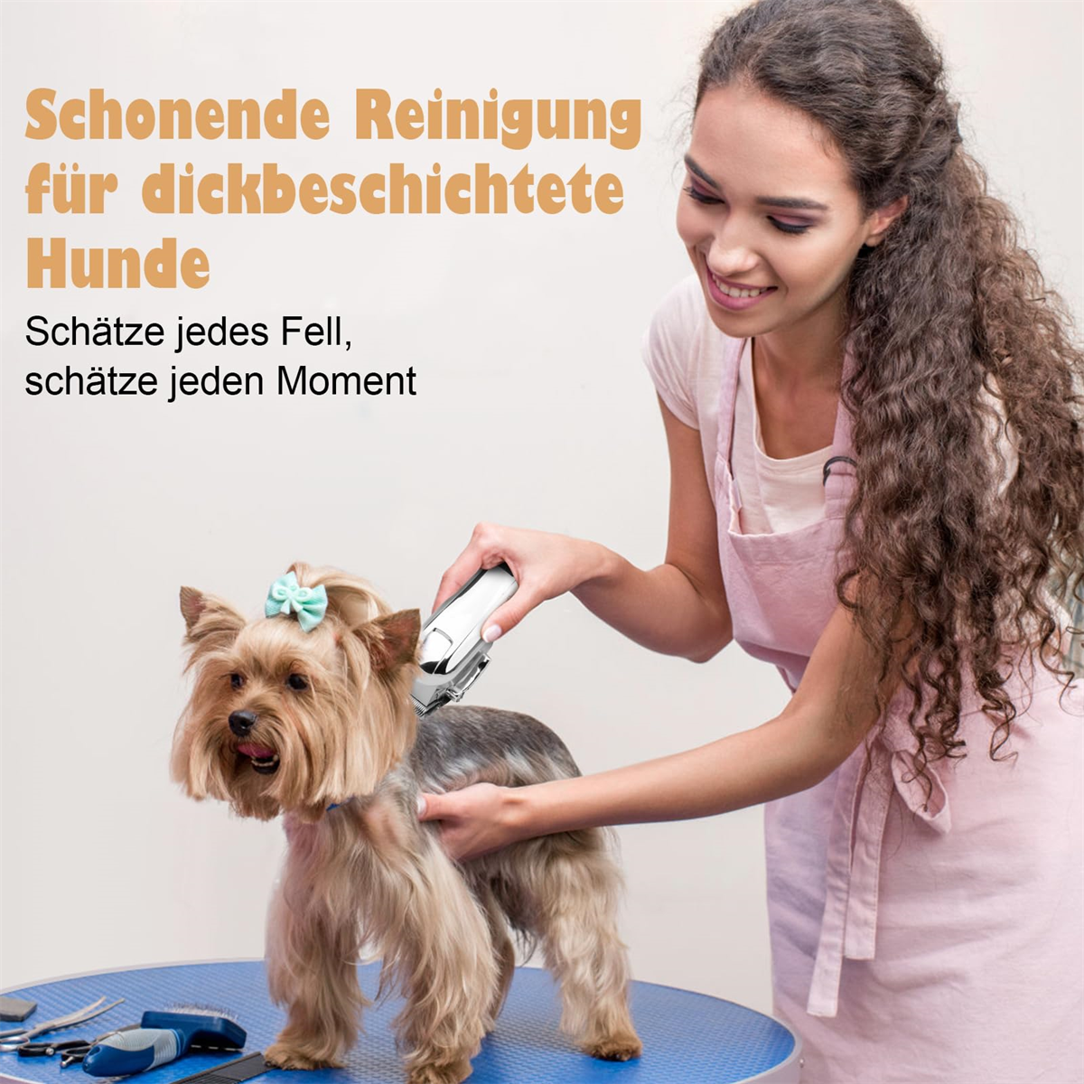Eine Frau pflegt einen kleinen Hund mit einem Haarschneider. Der Hund sitzt auf einem blauen Tisch.