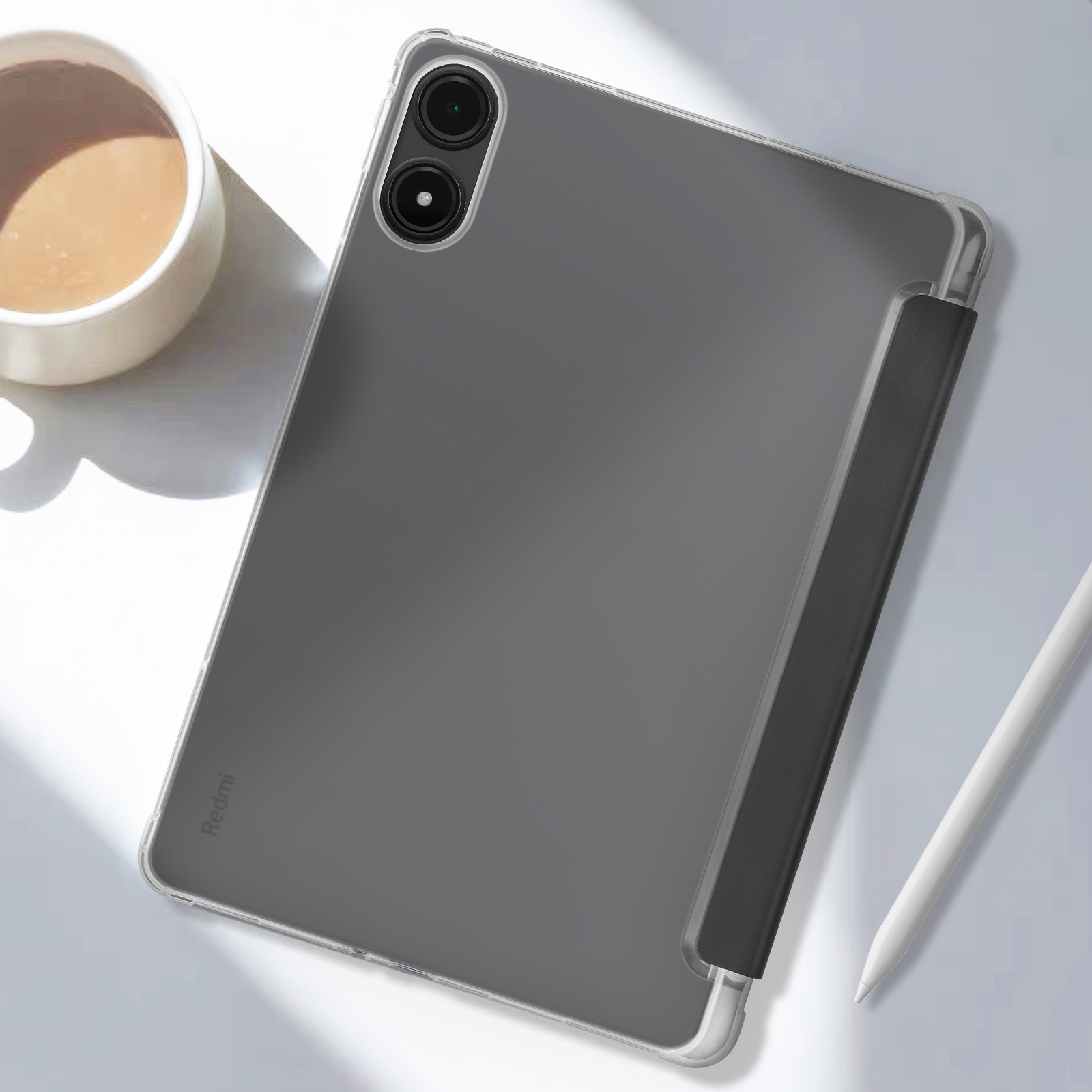 Custodia per tablet con un tablet all'interno, una tazza e una penna stilo sul tavolo.