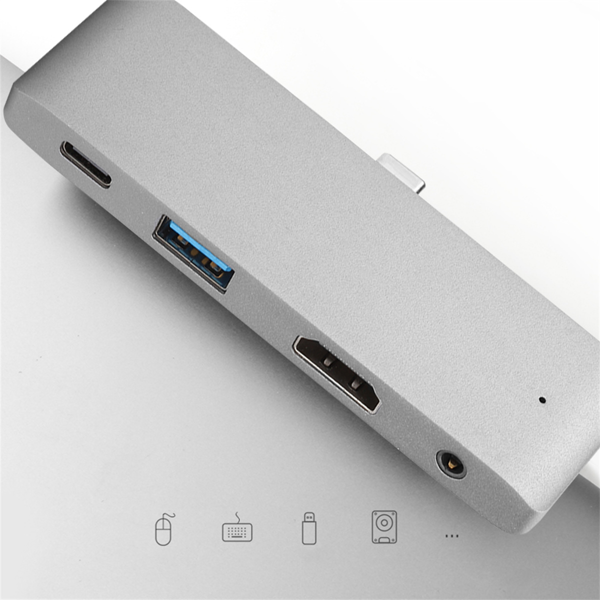 Silberner USB-Hub mit Anschlüssen, weiße Oberfläche.