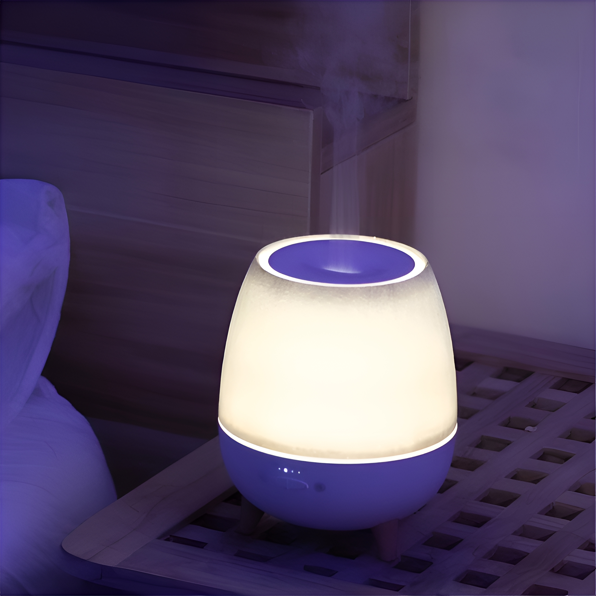 Beleuchteter, oval geformter Aromadiffusor auf einem hölzernen Nachttisch mit lila Licht.
