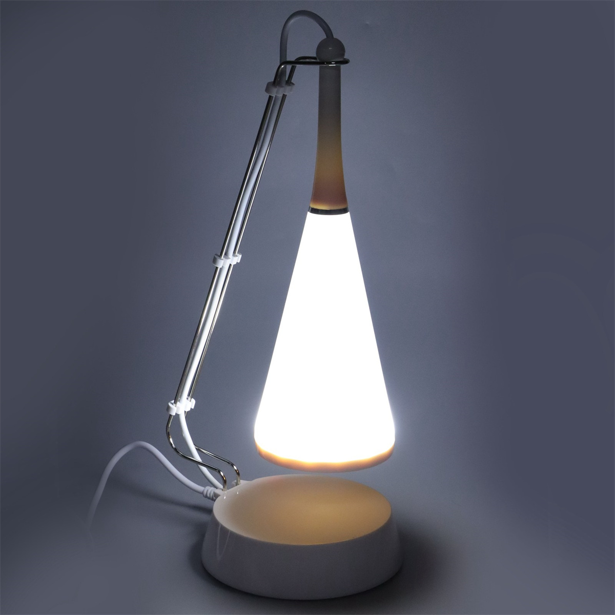 Moderne Schreibtischlampe mit hellem, kegelförmigem Licht. Die Lampe ist weiß mit silbernem Arm.