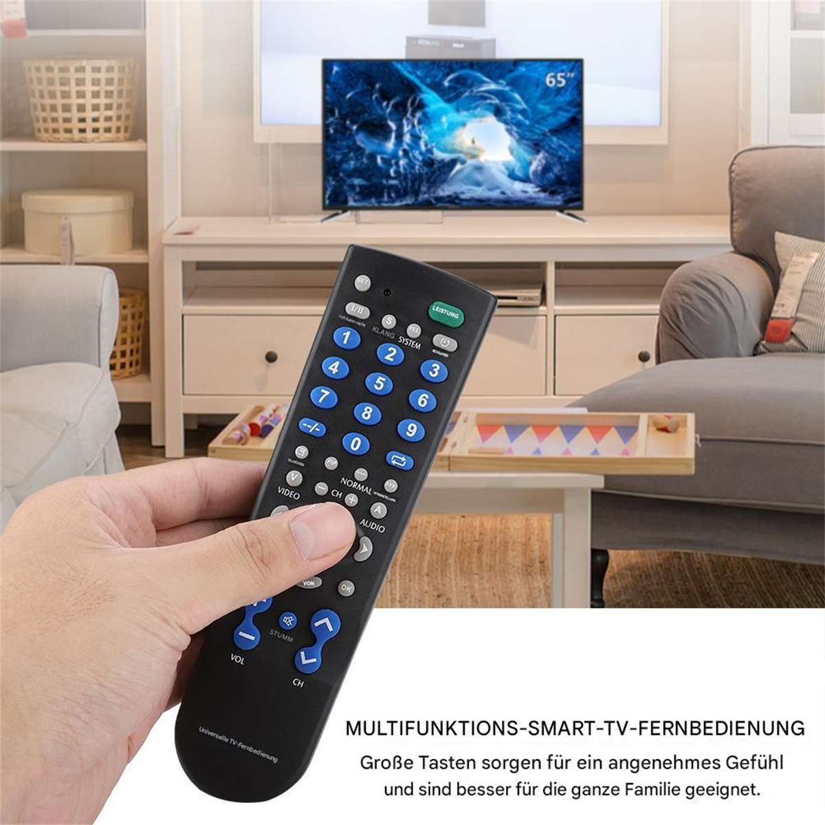 Eine Hand, die eine schwarze TV-Fernbedienung mit vielen Tasten vor einem Fernseher hält.