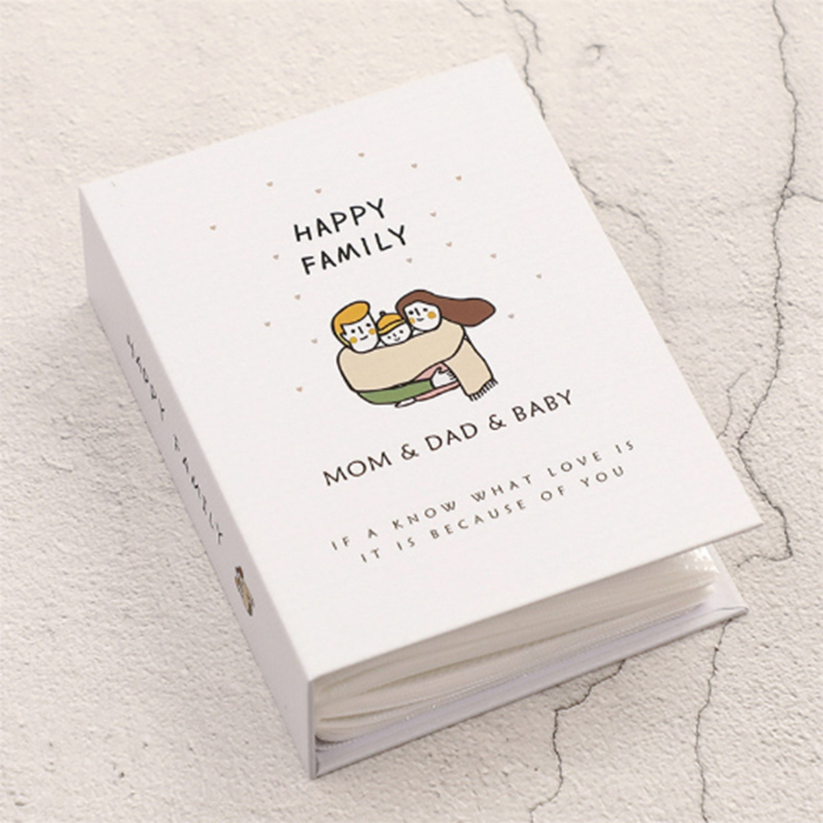Ein weißes Fotoalbum mit einer Cartoon-Familie auf dem Cover. Der Text lautet "Happy Family".