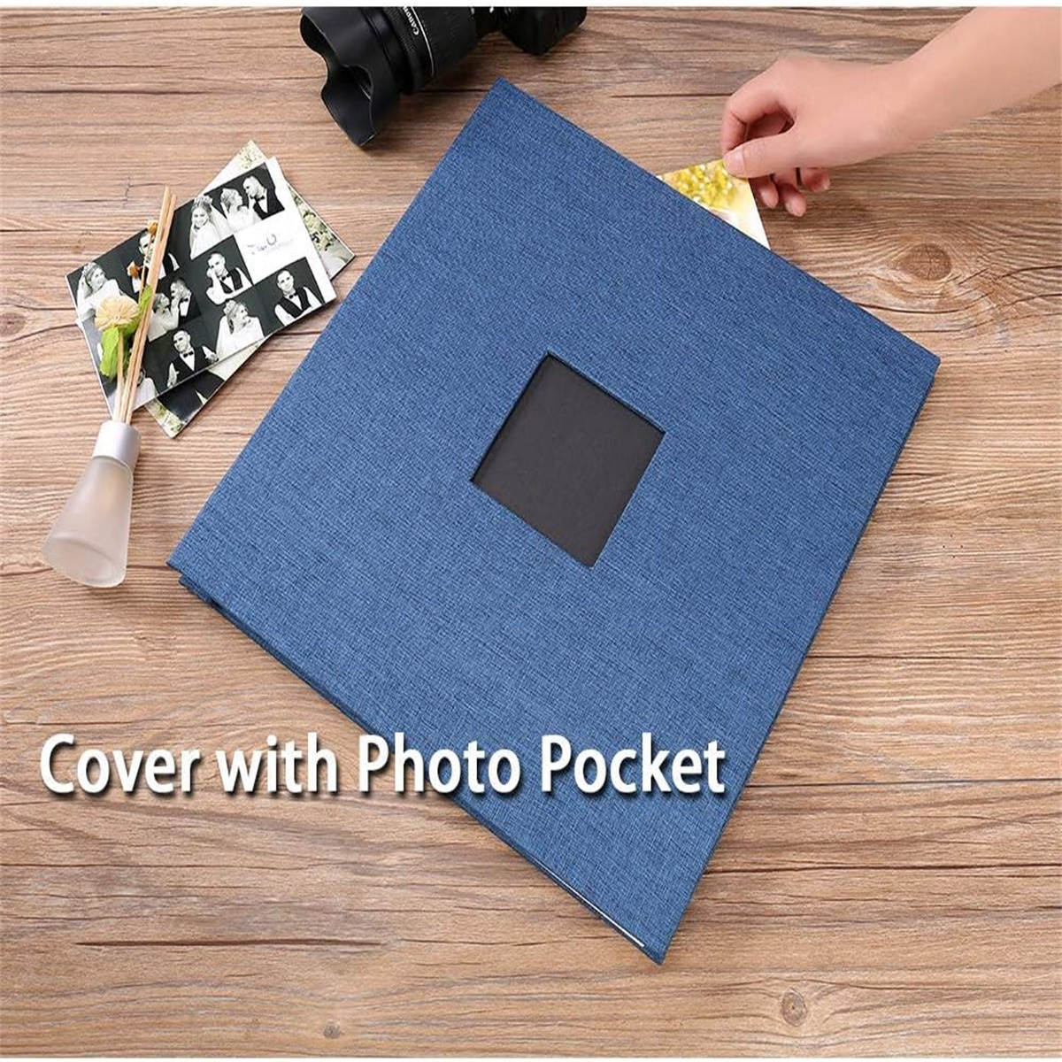 Ein blaues Fotoalbum auf einer Holzoberfläche. Es hat ein quadratisches Fenster für ein Foto.