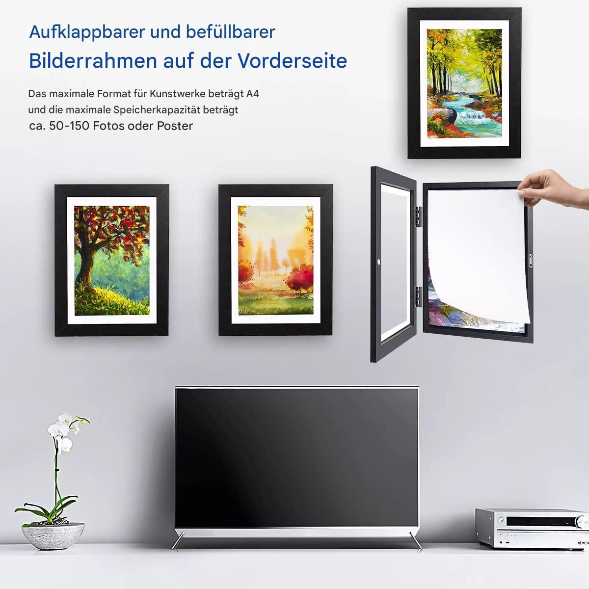 Mehrere gerahmte Landschaftsbilder. Ein Rahmen ist offen und zeigt ein weißes Papier. Ein Fernseher und eine Stereoanlage stehen auf dem Tisch.