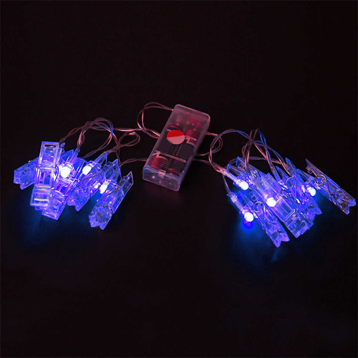 Eine Lichterkette mit blauen LEDs und Wäscheklammern, beleuchtet auf dunklem Hintergrund mit Batteriepack.