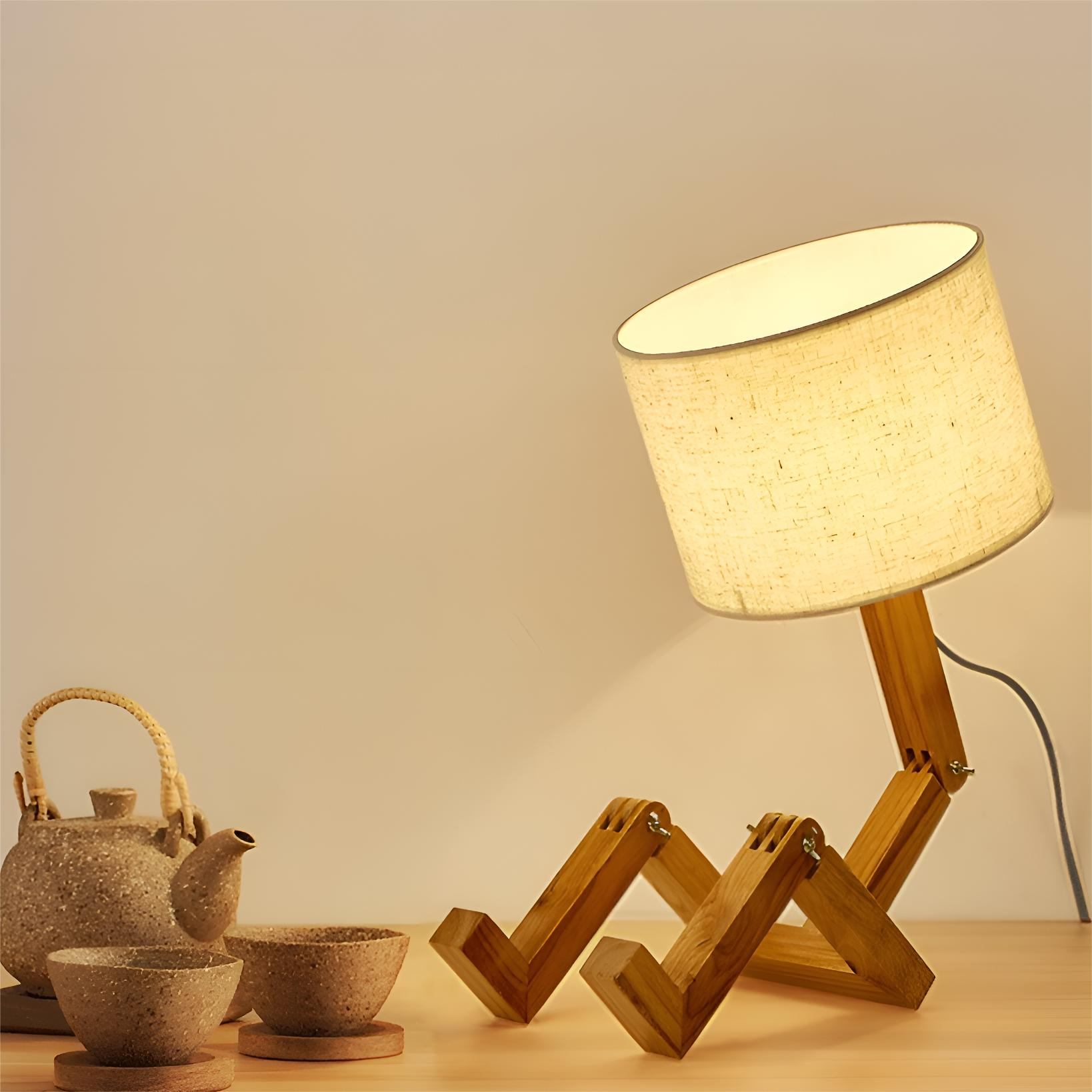 Holzlampe, geformt wie eine Person, mit Lampenschirm, und daneben ein Teeservice.
