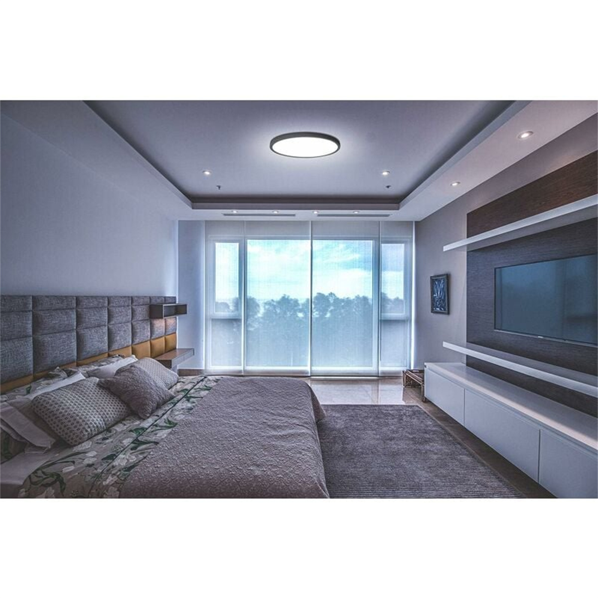 Schlafzimmer-Innenraum mit Bett, Kopfteil, Deckenleuchten, großem Fenster und TV an der Wand.