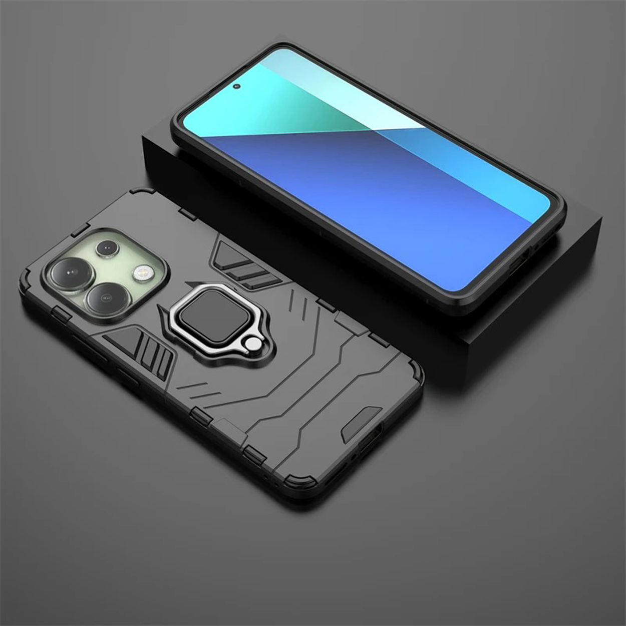 Coque de téléphone noire avec support d'anneau, sur une surface noire. Un téléphone est également dans le cadre.