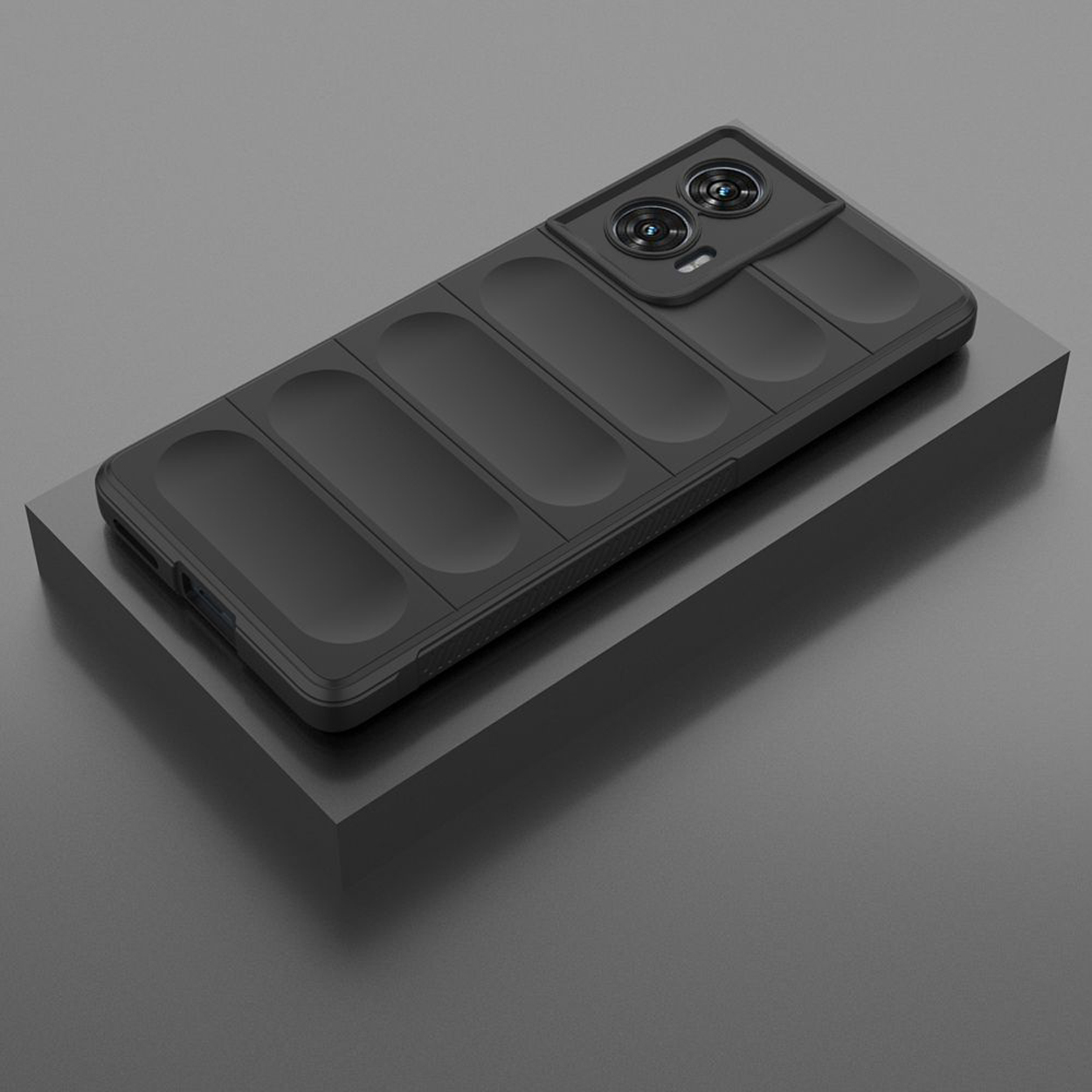 Coque de téléphone noire avec des crêtes horizontales, reposant sur une surface grise, avec une ombre.
