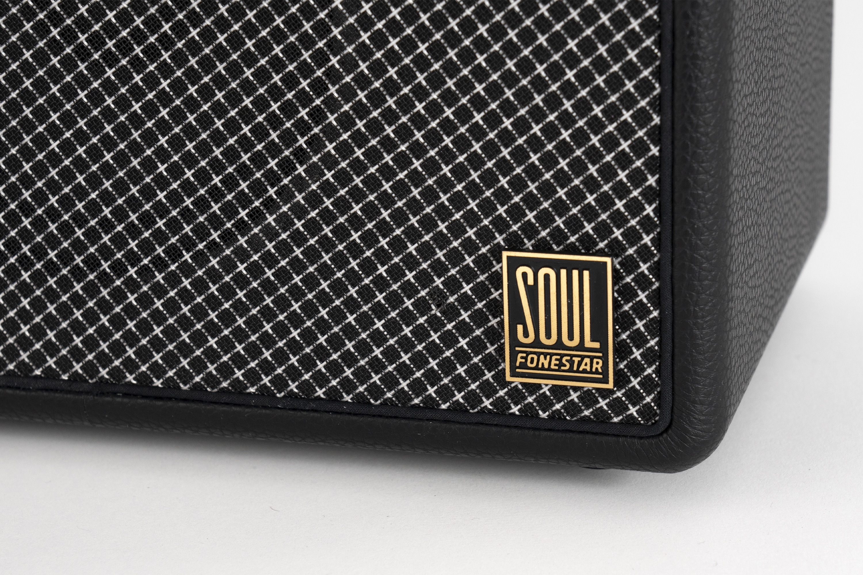 Primer plano de la parte frontal de un altavoz negro. Se ve un logotipo dorado de Soul Fonestar en la tela.