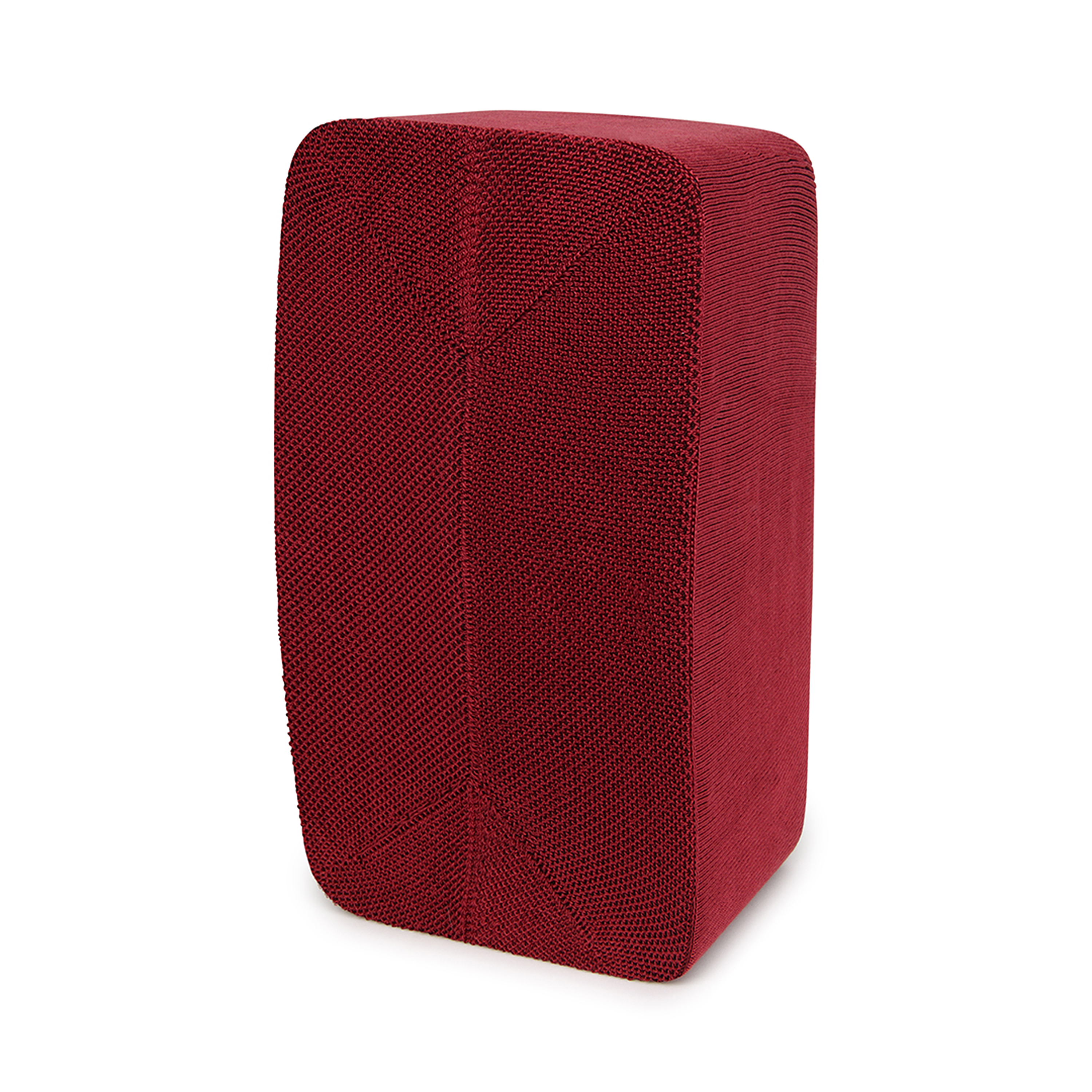 Un bloc rouge rectangulaire avec une surface texturée, debout sur un fond blanc.