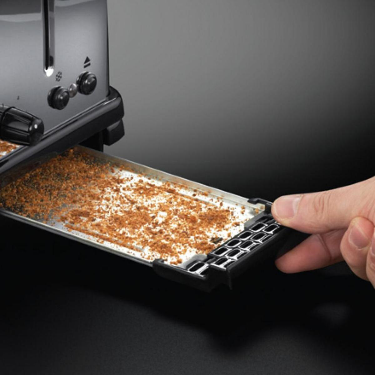 Ein Toaster mit herausgezogener Krümelschublade, die Krümel zeigt.