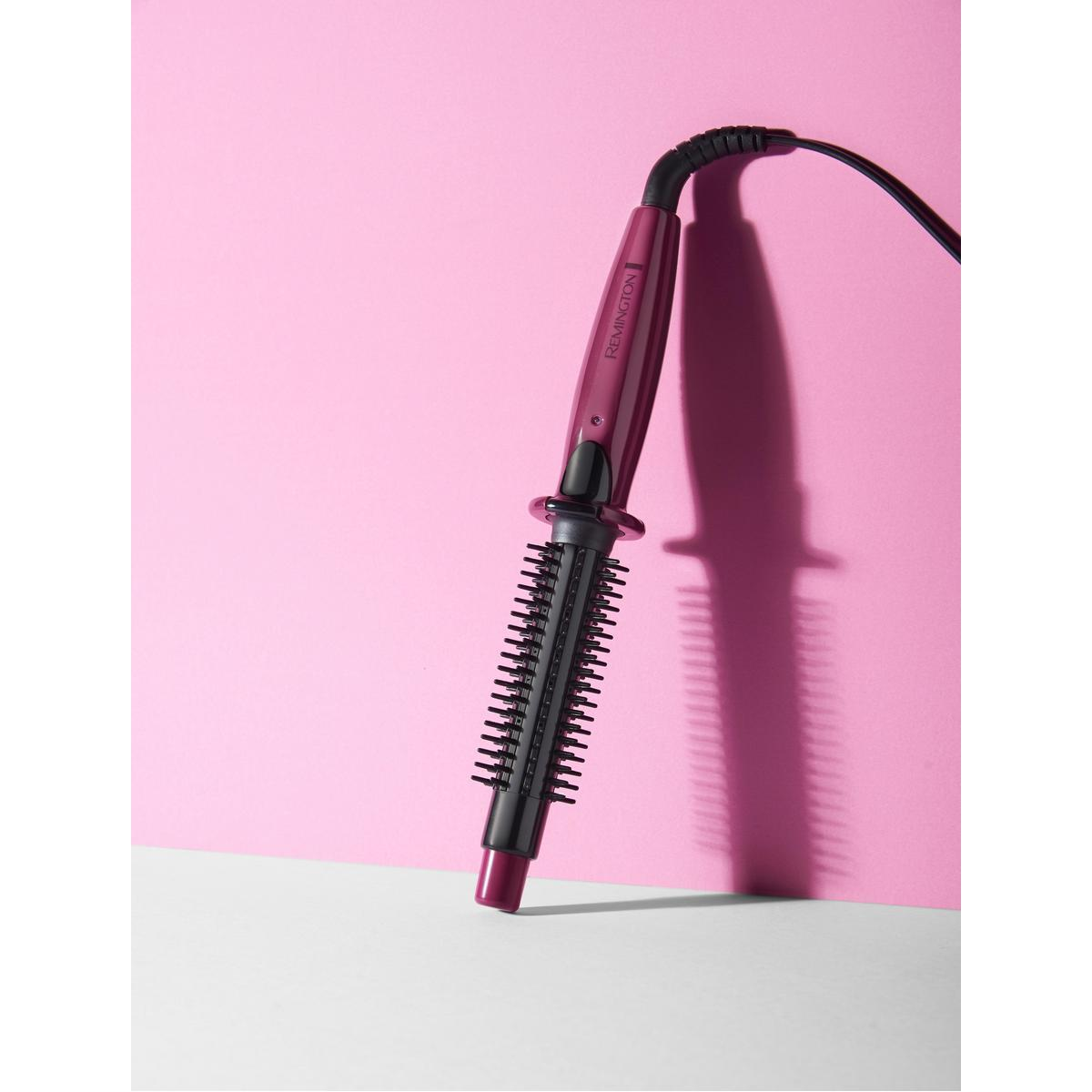 Lila Lockenstab auf rosa Hintergrund. Schwarzes Kabel ist befestigt.