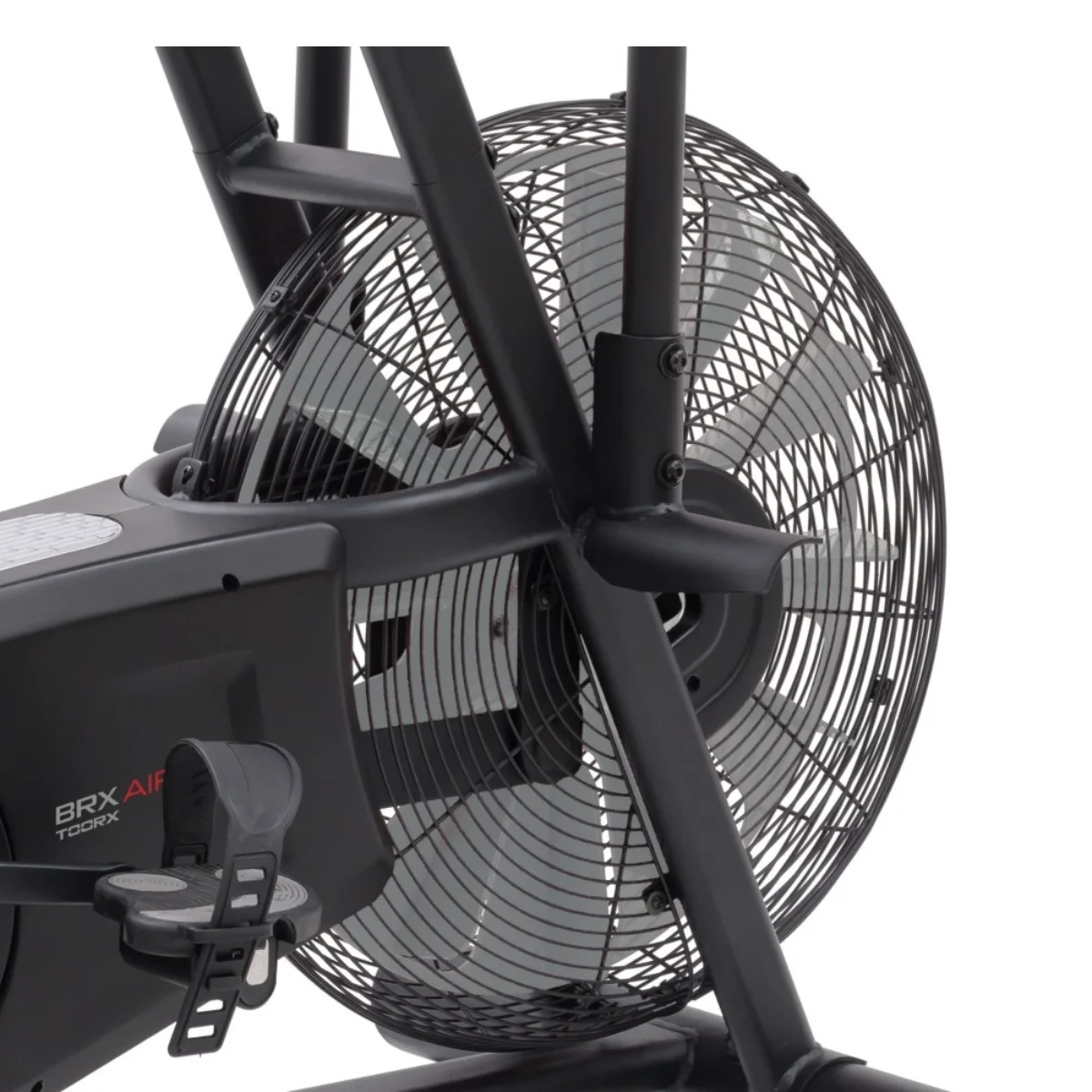 Close-up van een zwarte fitnessfietsventilator en pedalen. De ventilator heeft een mesh-ontwerp.