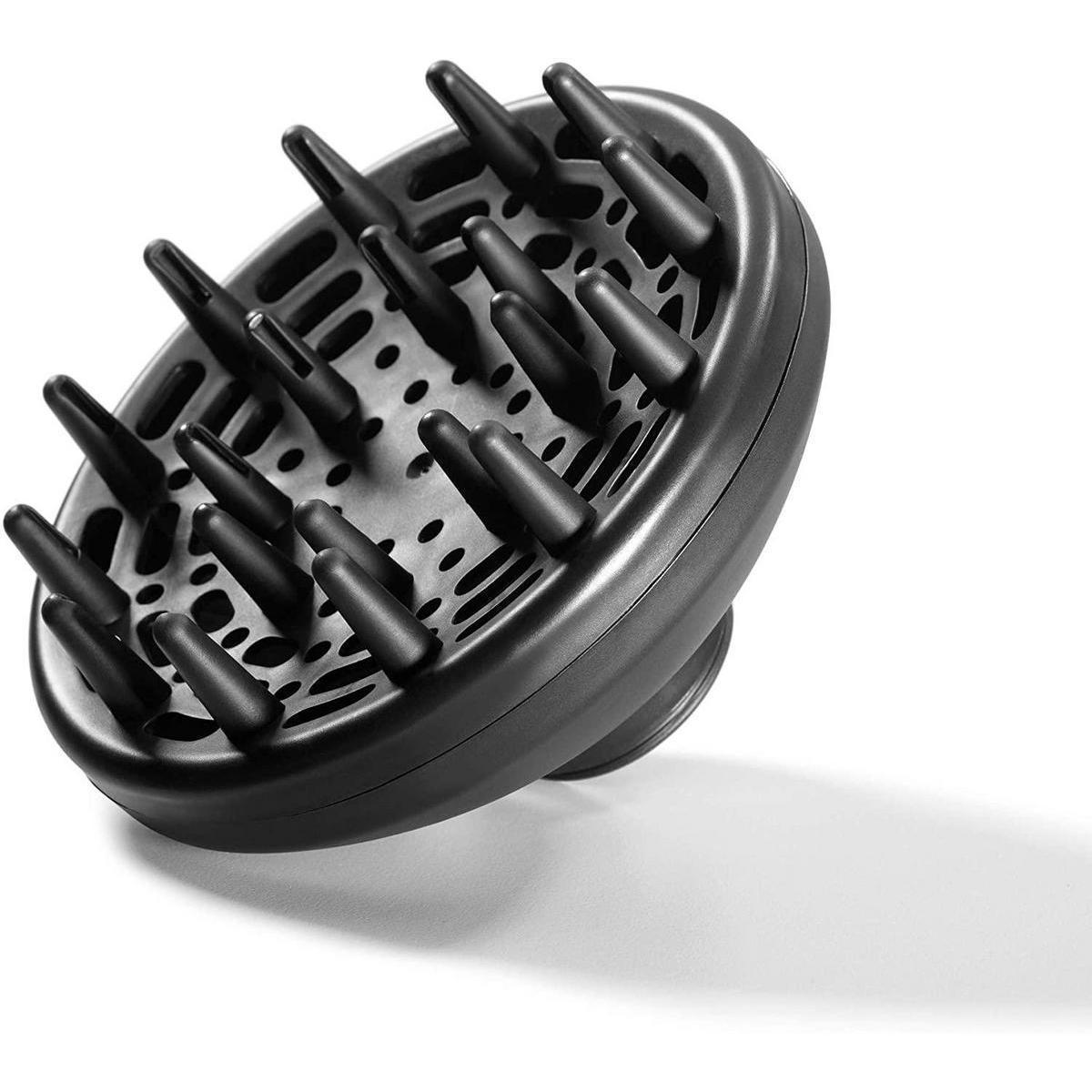 Un accessorio diffusore nero per asciugacapelli, con numerosi spuntoni e fori, su sfondo bianco.