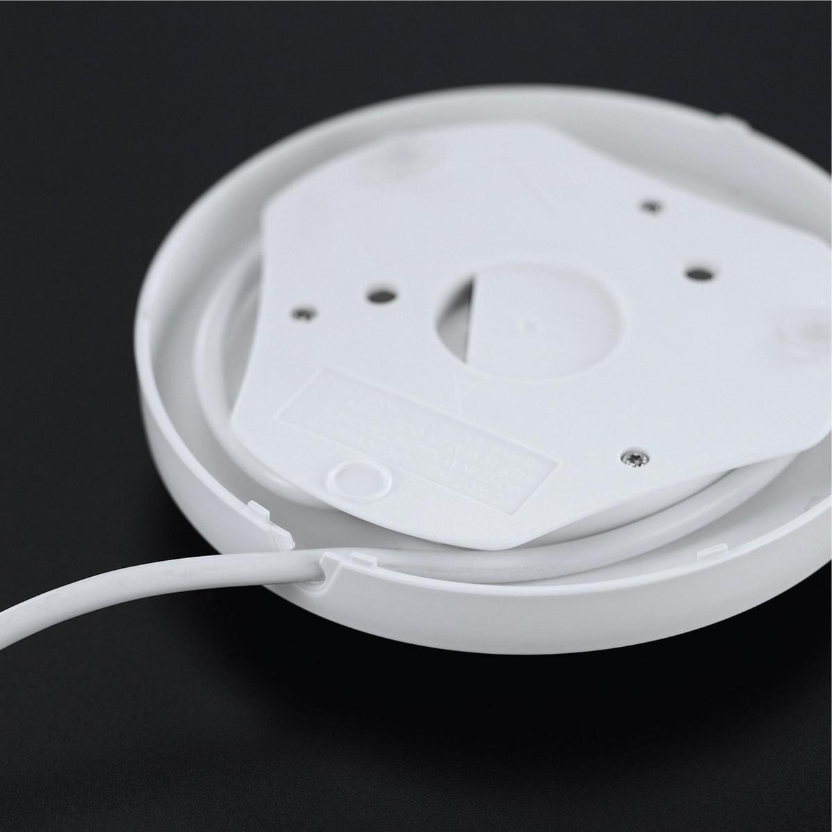 Weißer Sockel mit Kabel. Oben ist die Unterseite eines weißen, runden Objekts zu sehen.
