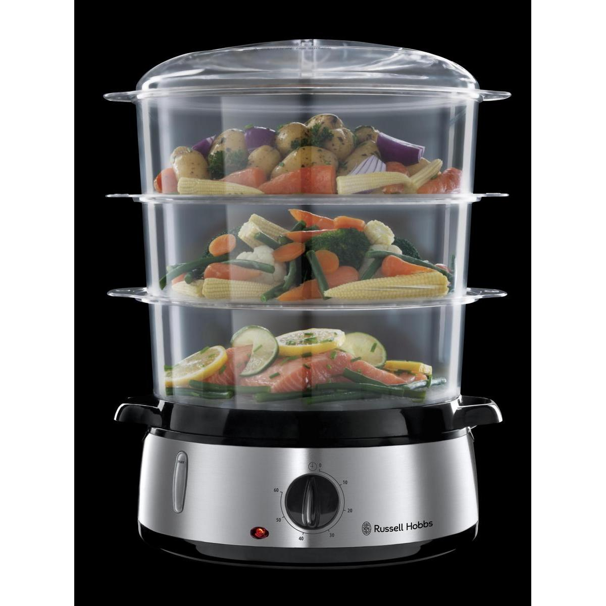 Trzypoziomowy parowar z warzywami i łososiem, na czarnym tle, z podstawą Russell Hobbs.