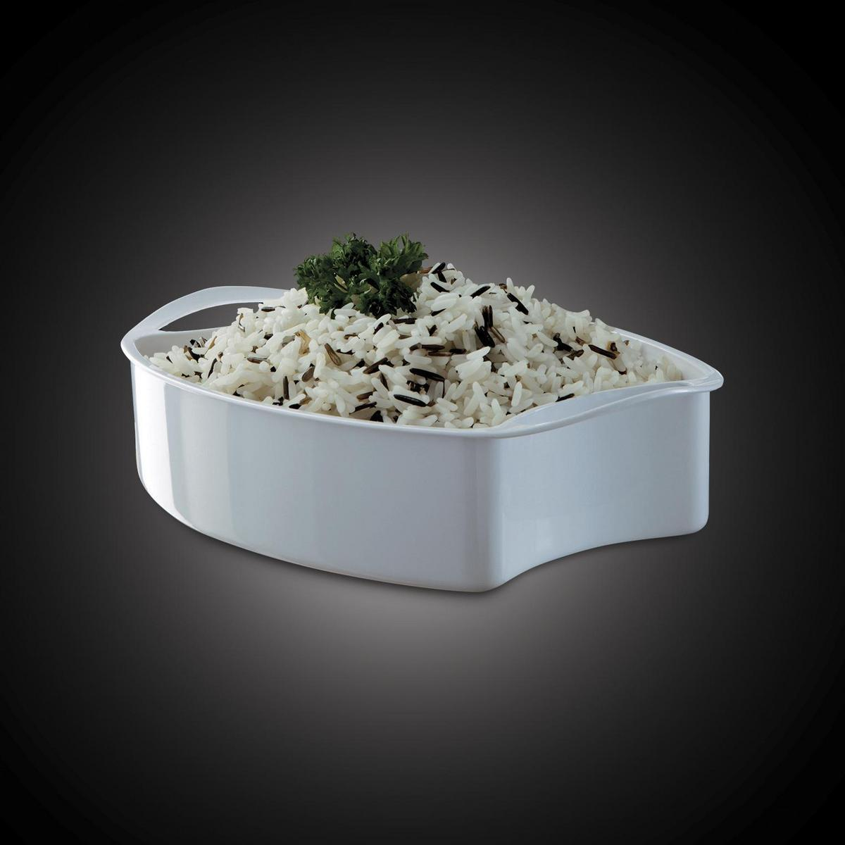 Biała miska z ugotowanym ryżem i dekoracją z pietruszki, na ciemnym tle.