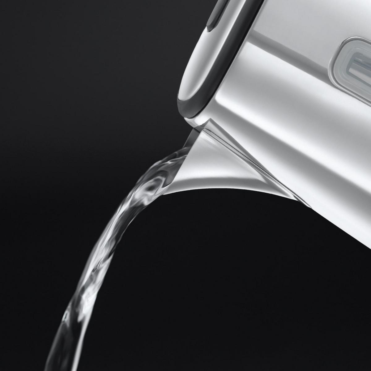 Un getto d'acqua versato da una brocca di metallo su sfondo nero.