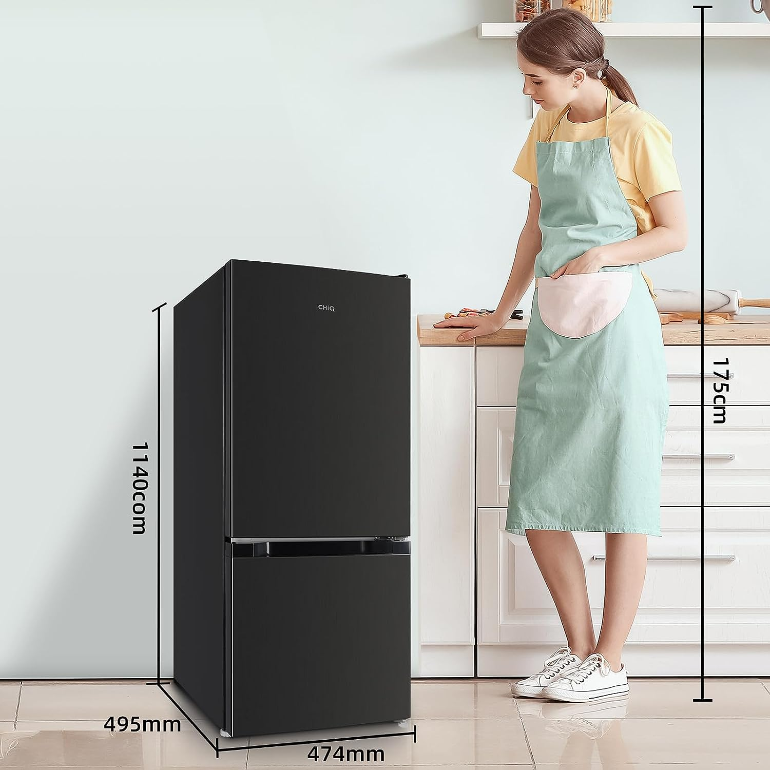 Schwarzer Kühlschrank mit Maßen, Frau steht in der Küche.