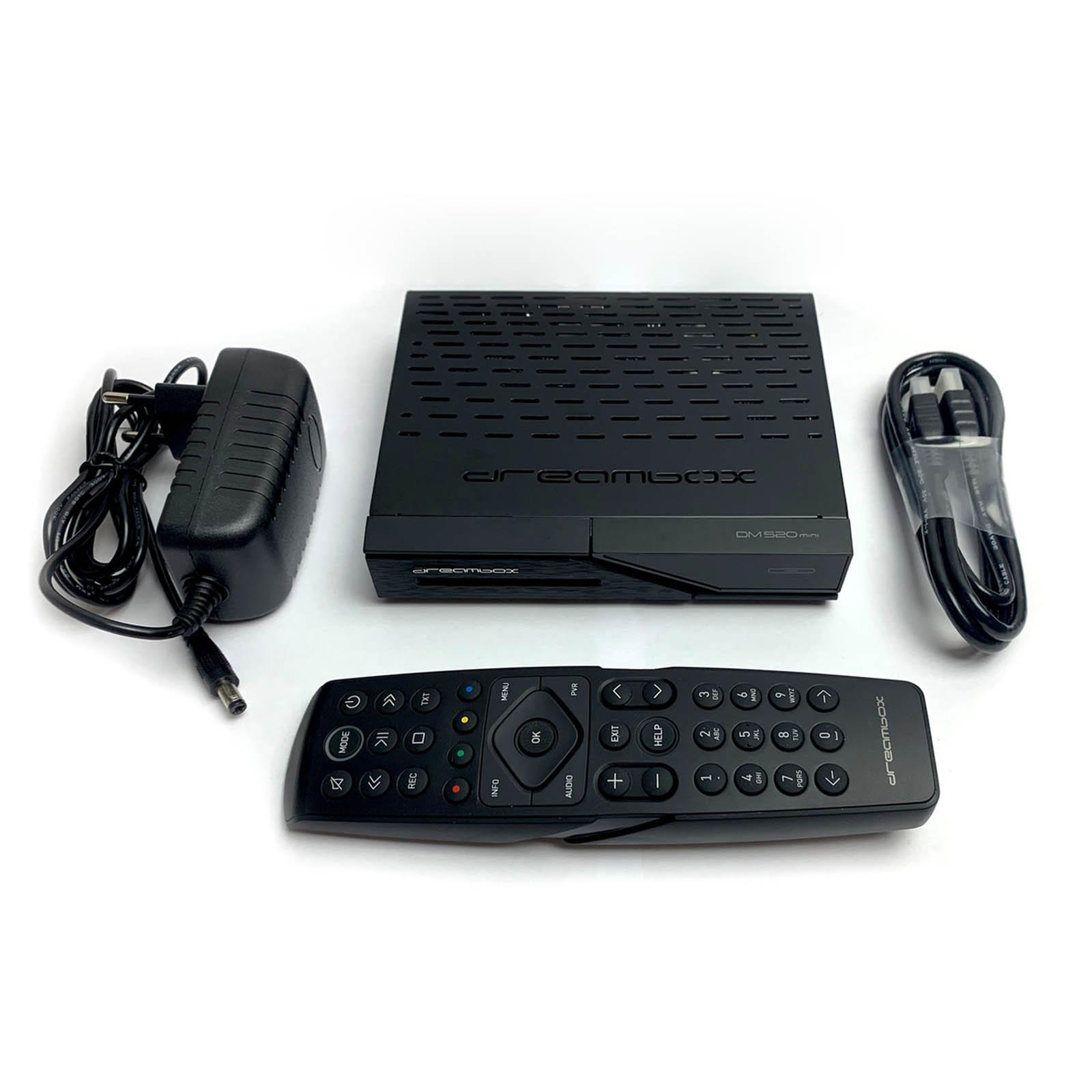 Schwarze DreamBox, Fernbedienung, Netzteil und Kabel auf weißer Oberfläche.