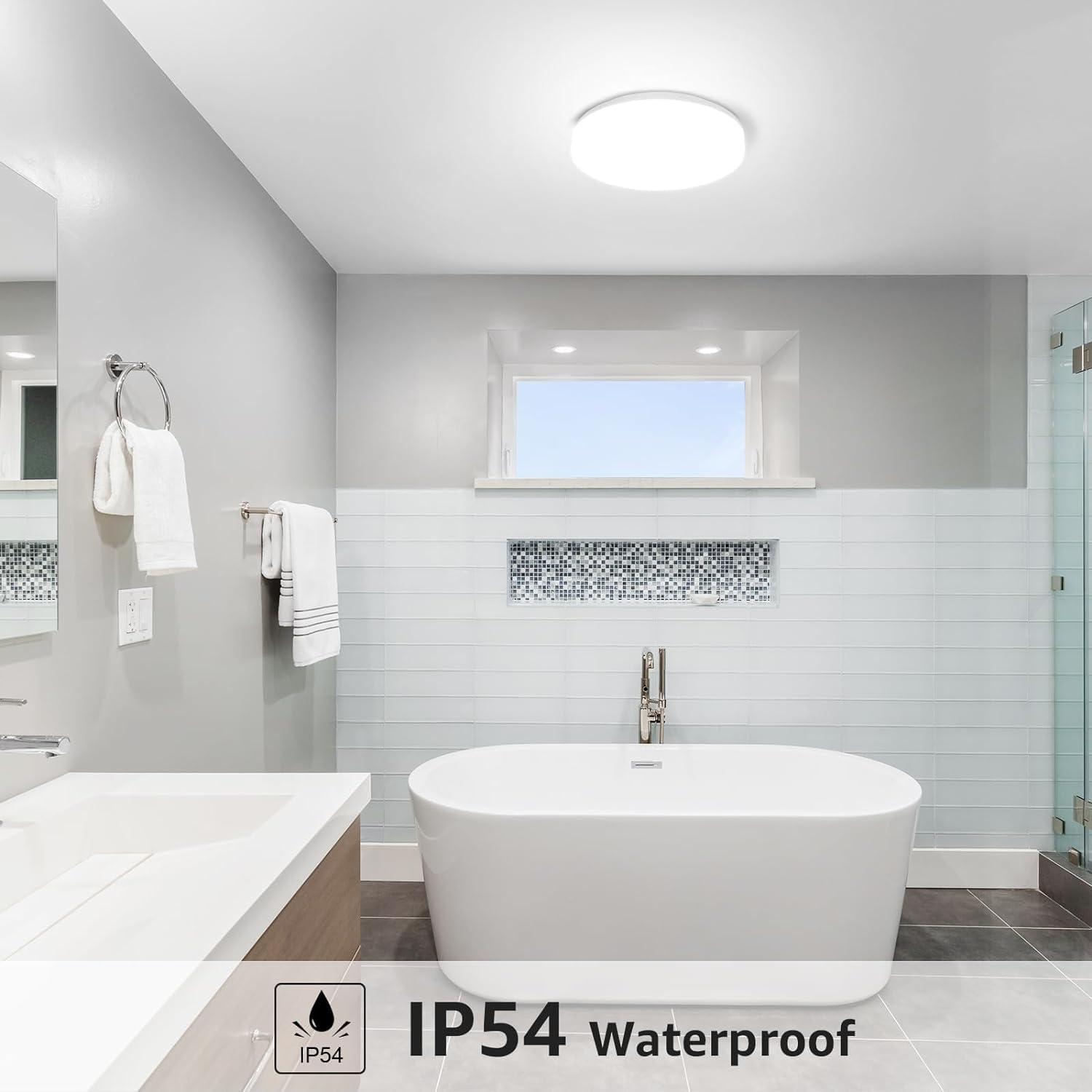 Badezimmer mit weißer Badewanne, Leuchte und Fenster. Es hat eine IP54 wasserdichte Markierung.
