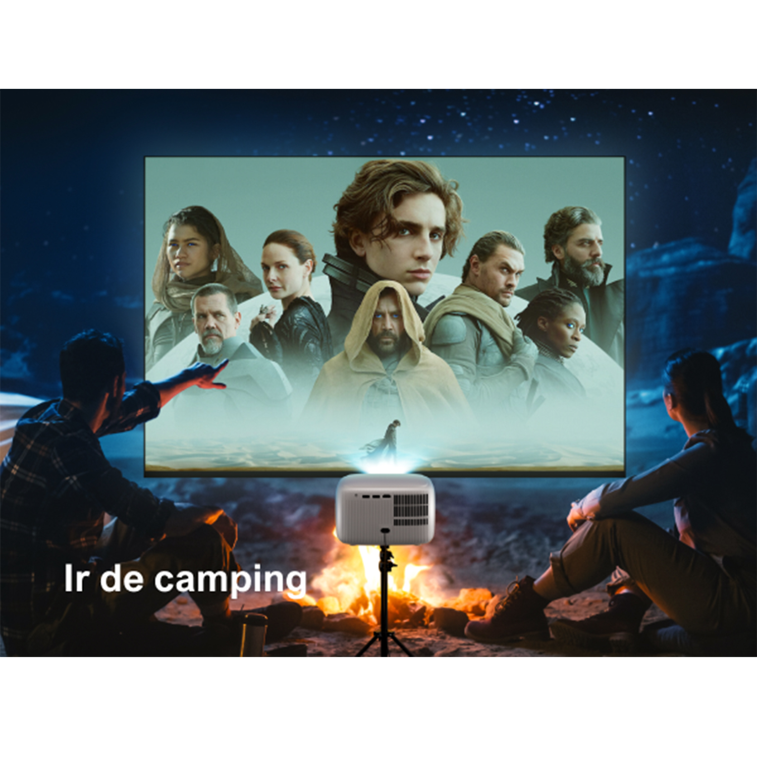 Dos personas ven una película proyectada por un proyector blanco en una pantalla. Están cerca de una fogata.
