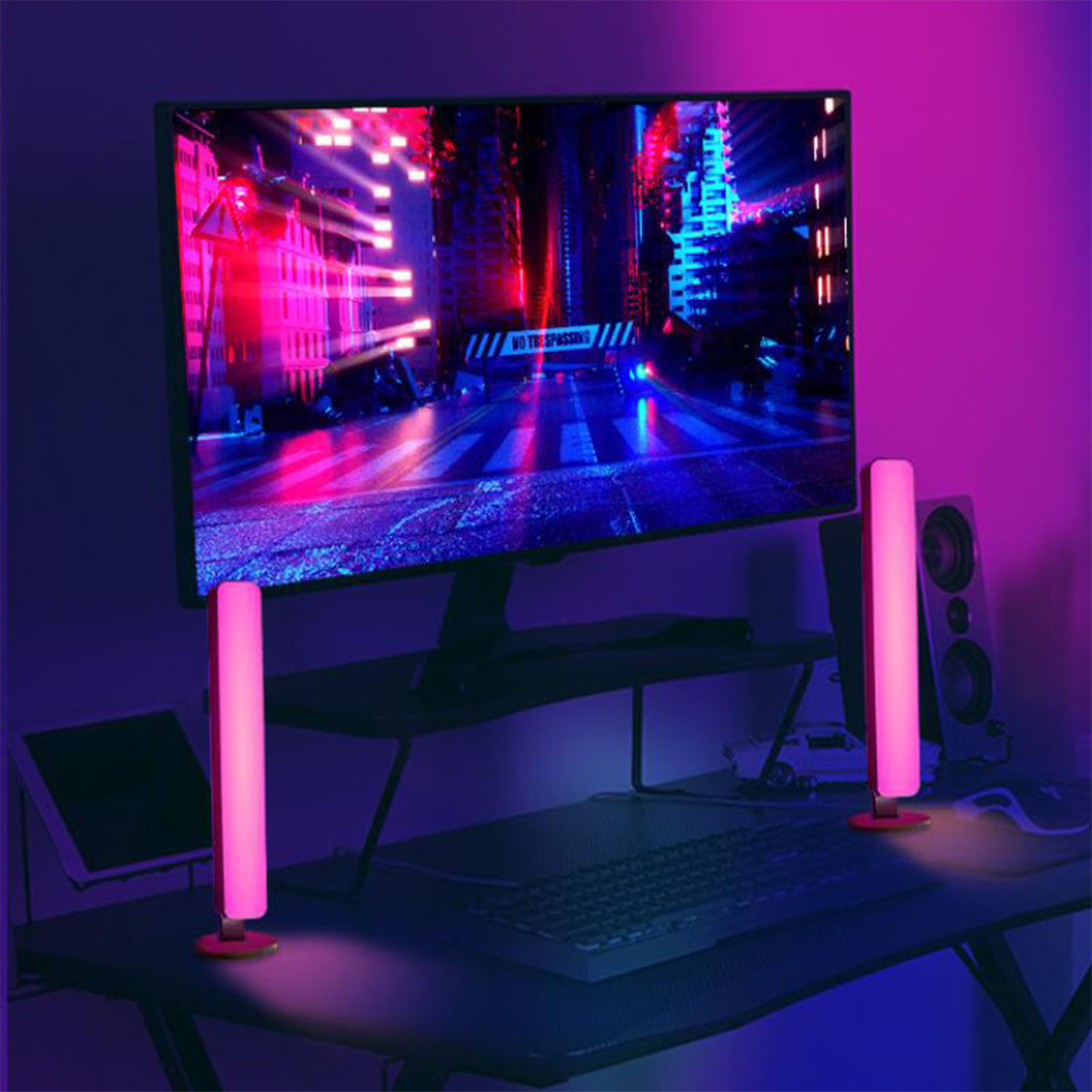 Gaming-Setup mit einem Monitor, der eine Stadtlandschaft anzeigt. Zwei rosa Lichter flankieren den Monitor.