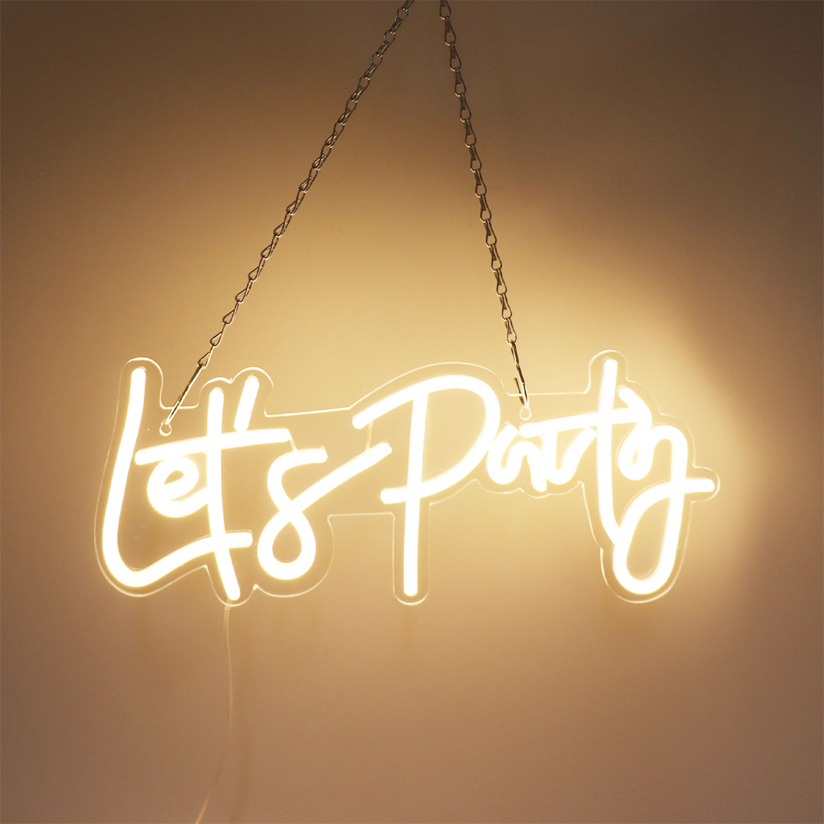 Neonschild mit der Aufschrift "Let's Party" in weißen Buchstaben, das an einer Wand hängt.