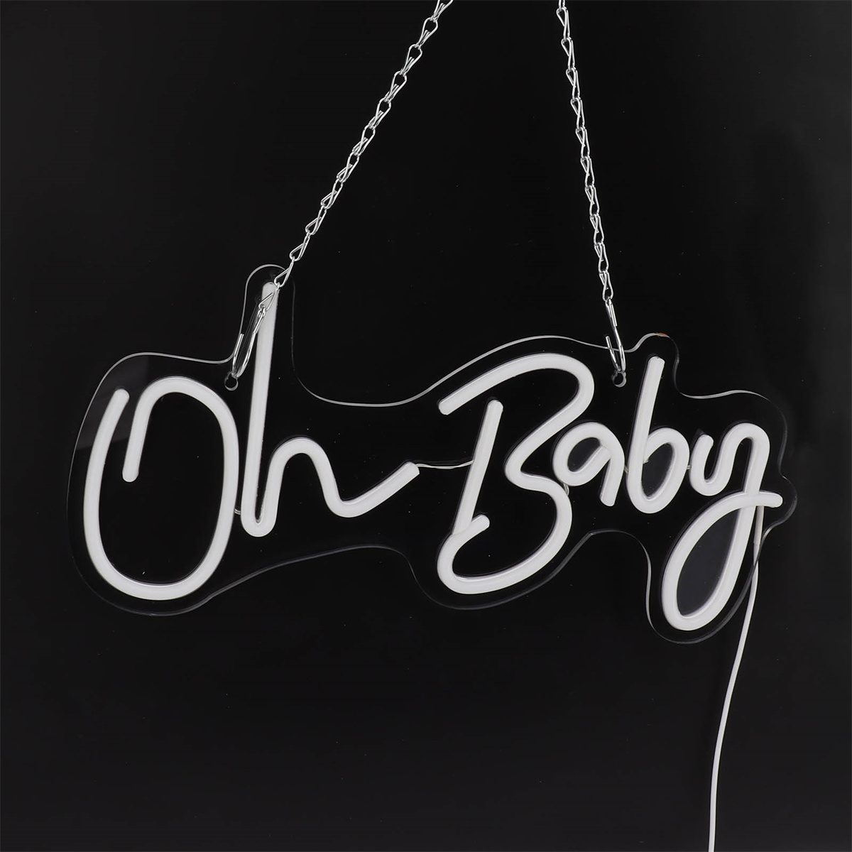 Ein Neonschild mit der Aufschrift 'Oh Baby', hängt vor schwarzem Hintergrund.