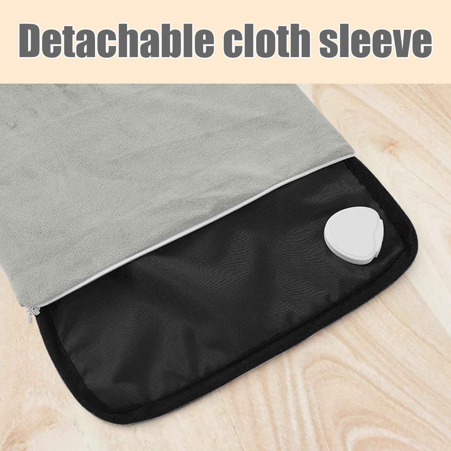 Una almohadilla térmica gris con una funda de tela desmontable y un botón de control blanco.