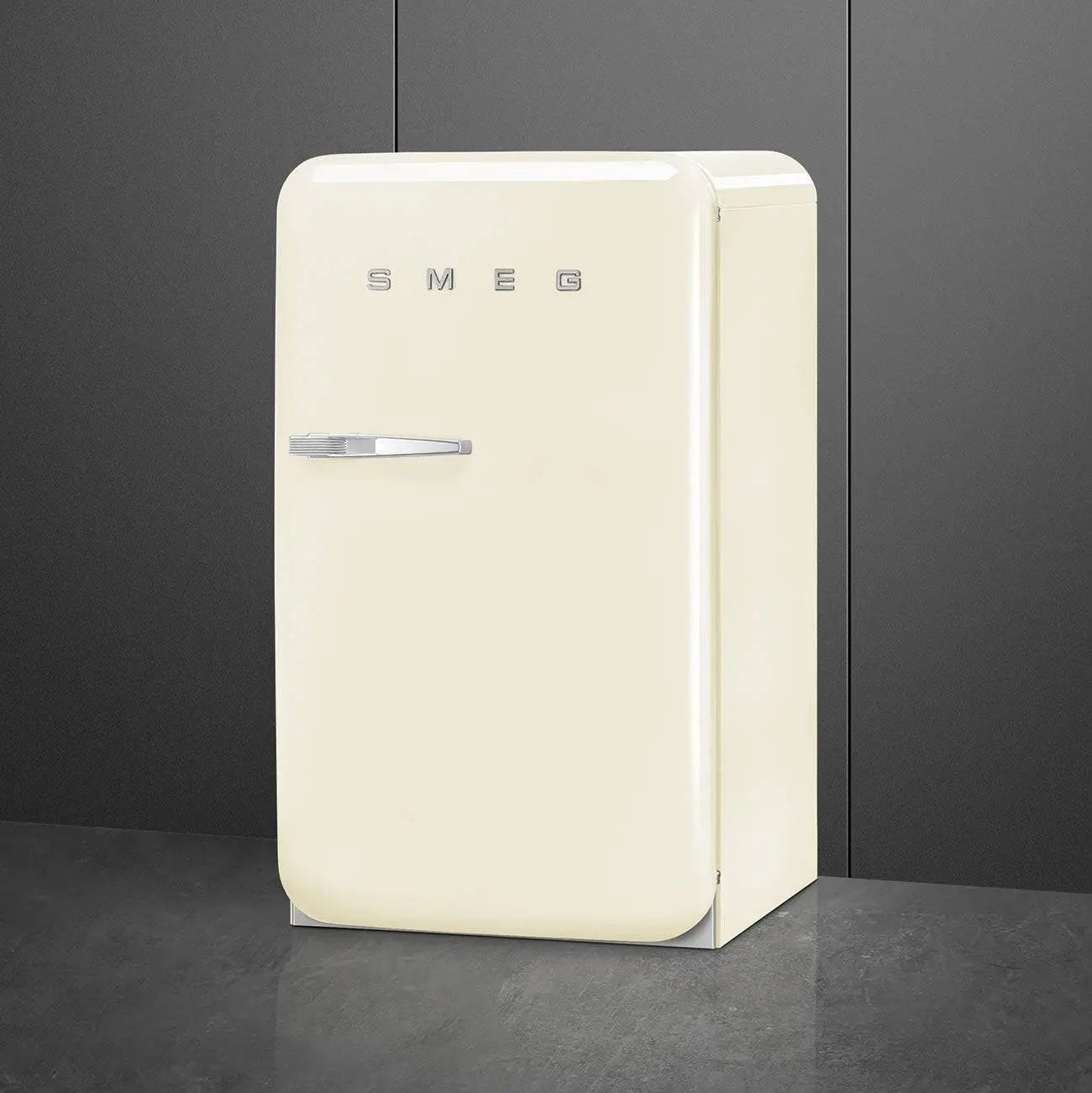 Refrigerador SMEG color crema, un refrigerador de estilo retro, sobre un suelo y fondo gris oscuro.
