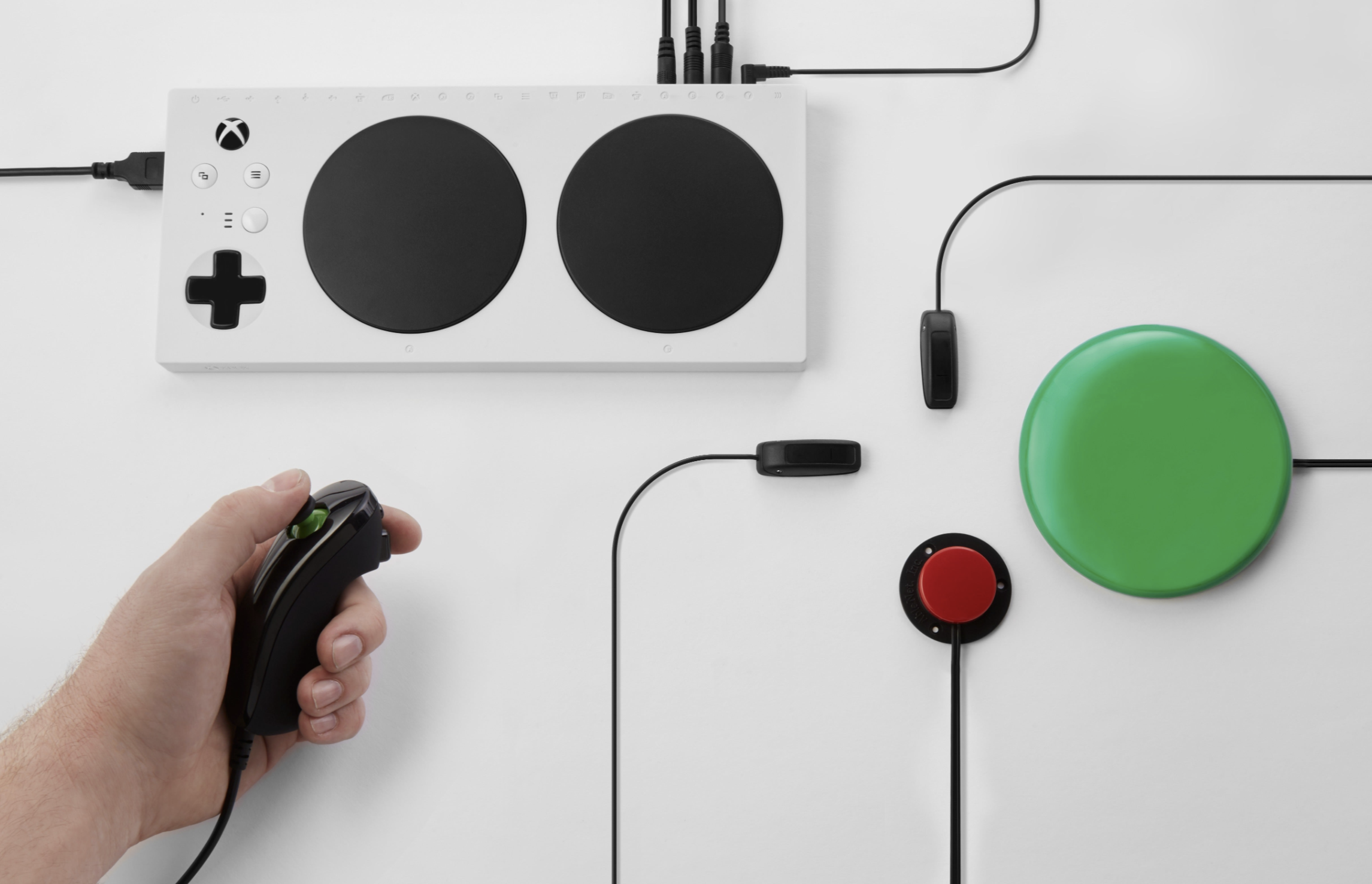 Controller di gioco bianco. Più pulsanti, controlli neri e verdi. Mano che tiene il controller.