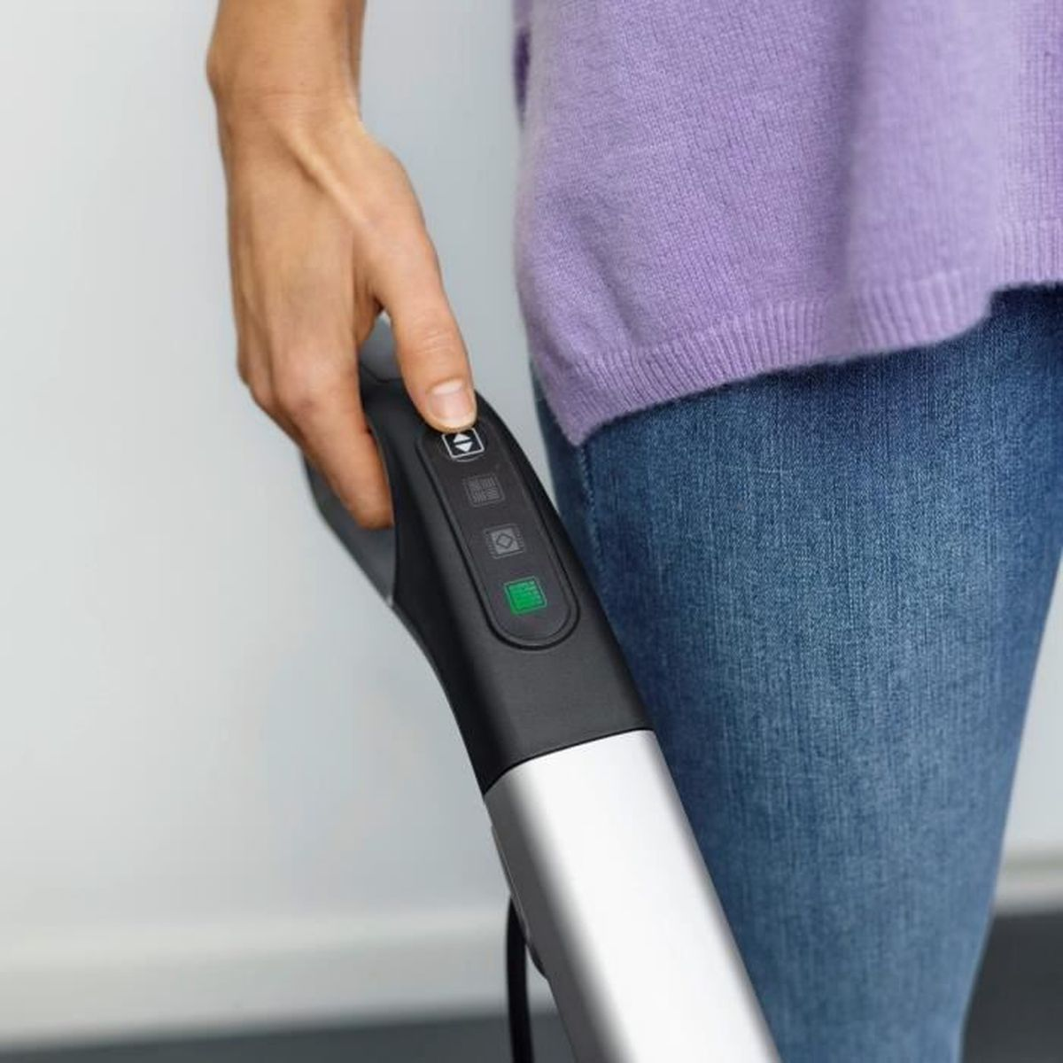 Ręka osoby naciskająca przycisk na srebrno-czarnym urządzeniu czyszczącym.