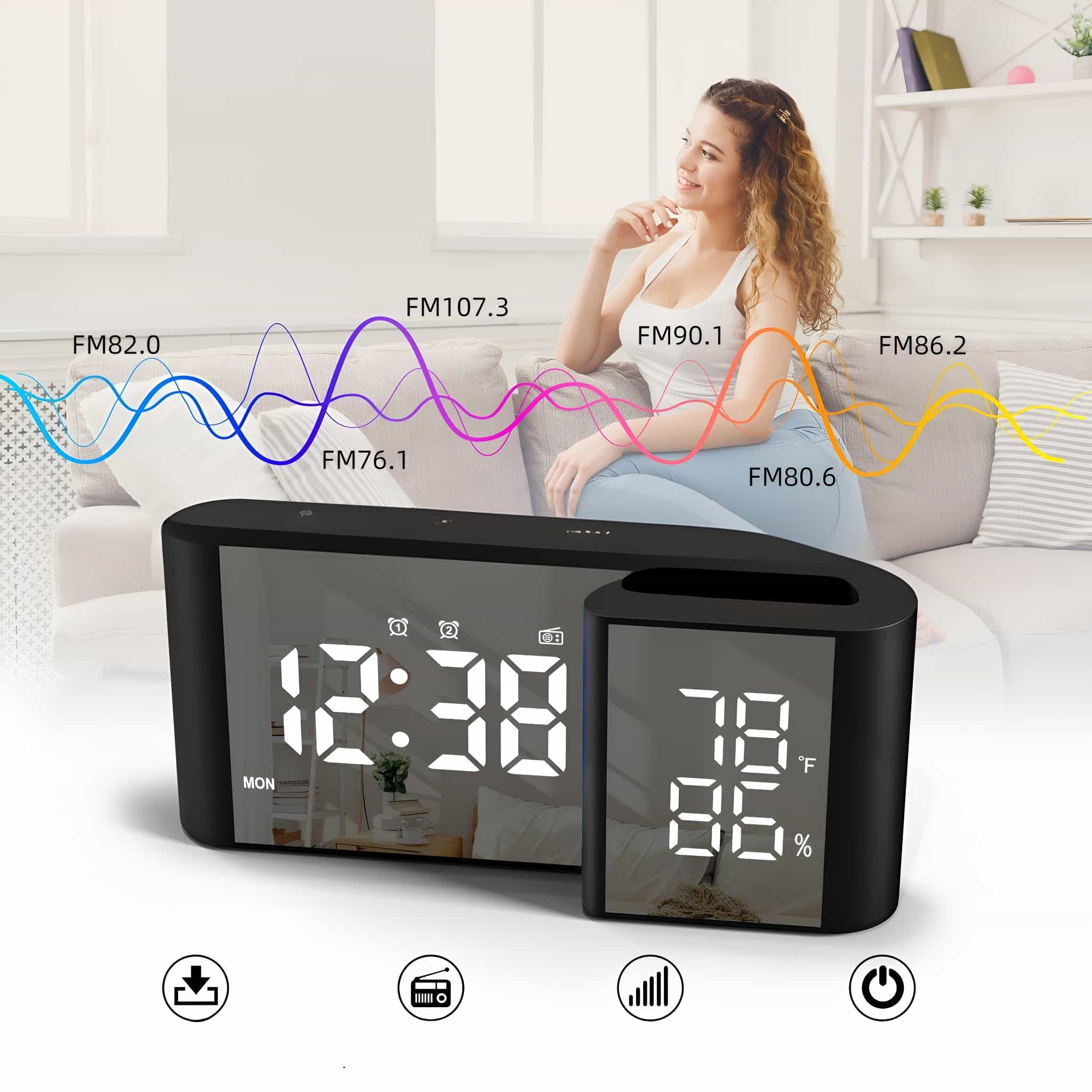 Schwarzer digitaler Wecker mit Display. Eine Frau sitzt im Hintergrund.