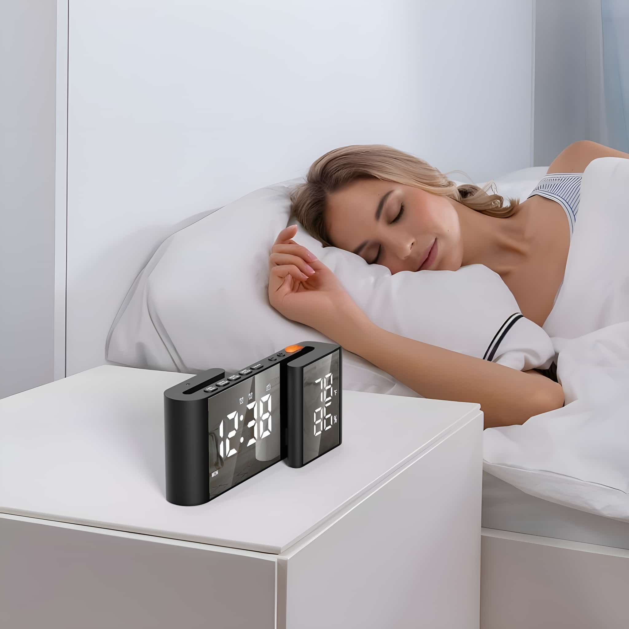 Eine Frau schläft im Bett, während eine schwarze Digitaluhr auf einem Nachttisch steht. Sie zeigt Uhrzeit und Temperatur an.