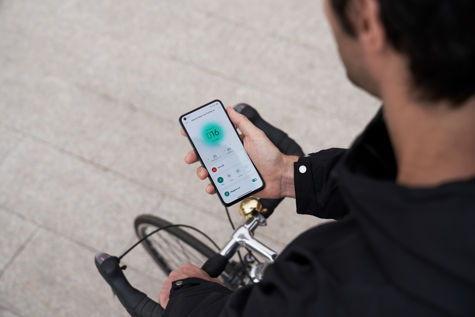 Un uomo che tiene in mano un telefono mentre è in bici, che mostra l'app per il ciclismo.