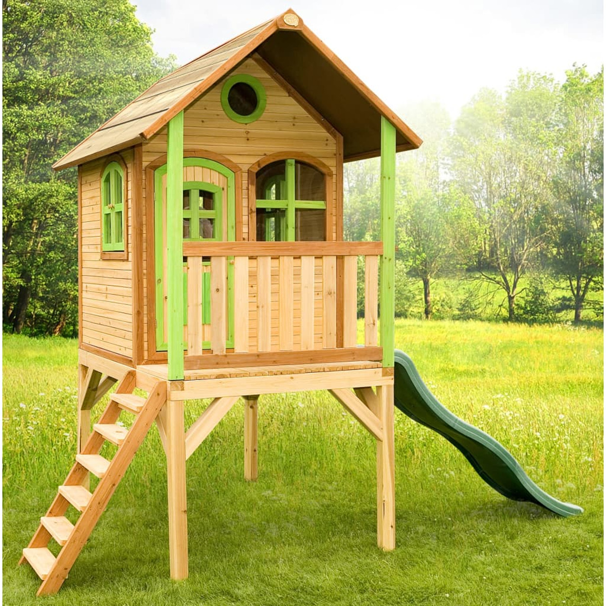 Holzspielhaus mit grünen Zierleisten, einer Rutsche und einer Leiter auf einer grünen Wiese.