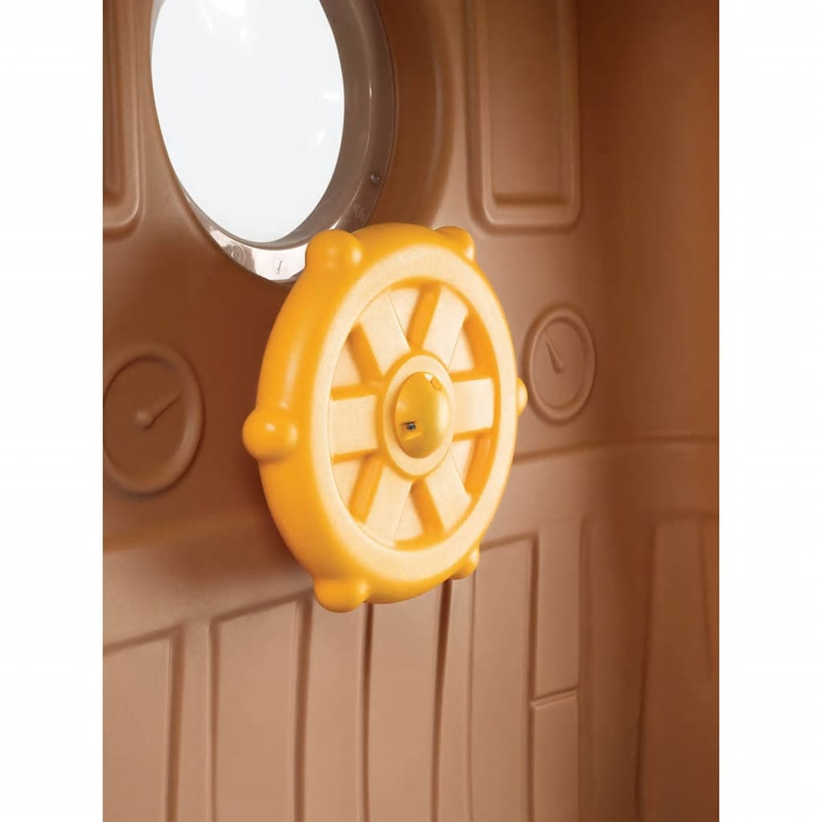 Ein gelbes Spielzeuglenkrad in einem braunen Spielhaus. Der Hintergrund ist ebenfalls braun.