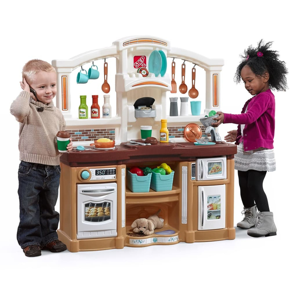 Due bambini giocano con un set da cucina giocattolo. Un bambino è al telefono.
