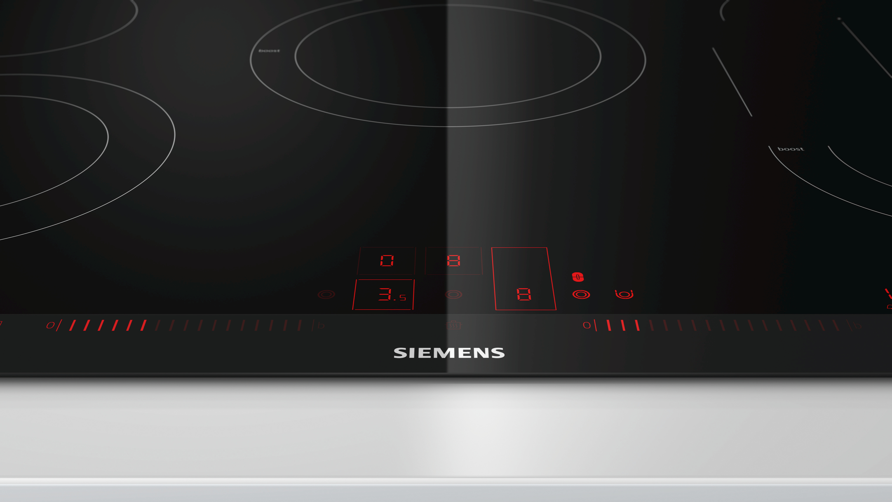 Schwarzes Induktionskochfeld mit rot beleuchteten Bedienelementen und Siemens-Logo auf weißer Oberfläche.
