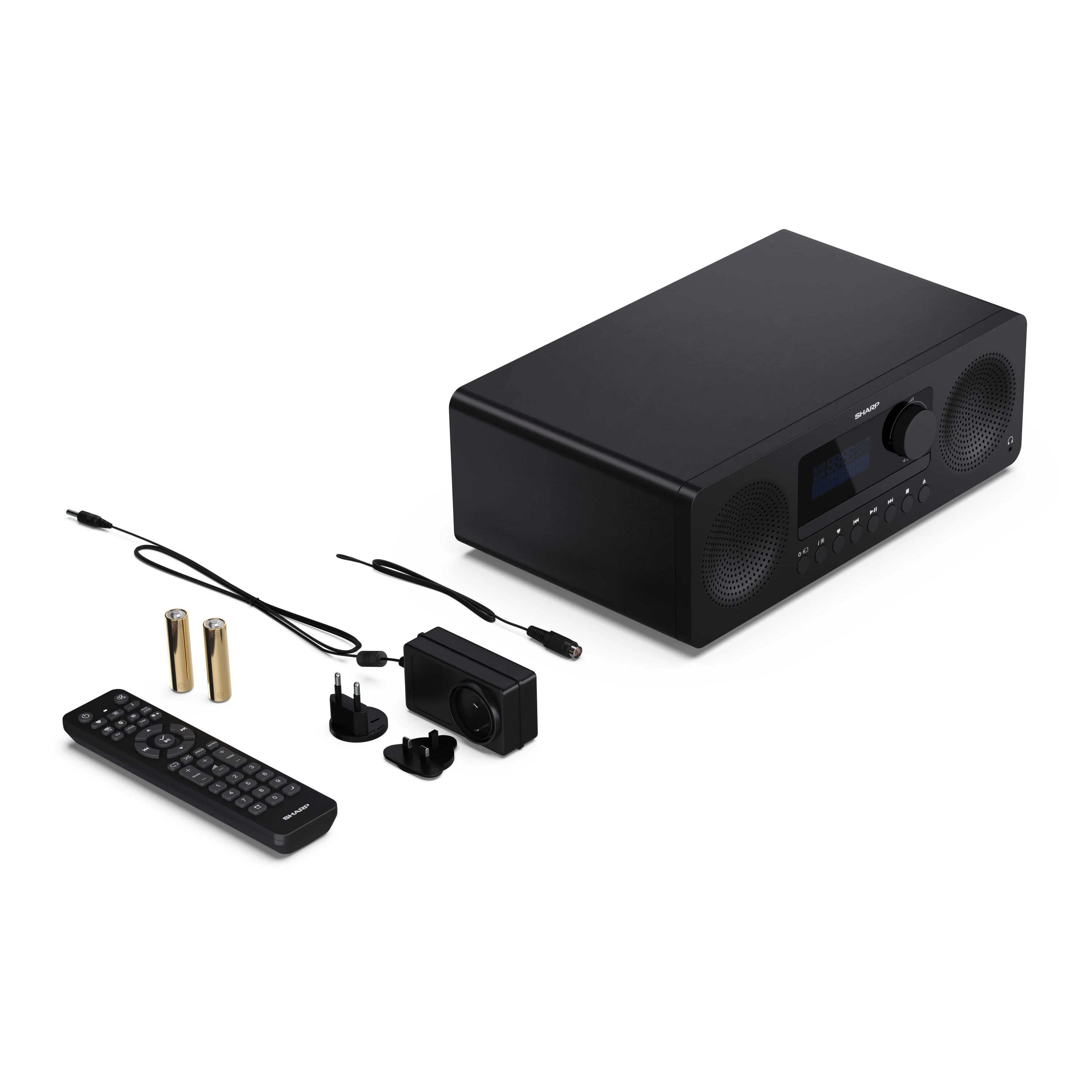 Radio negro con accesorios: mando, cables y enchufes. Aislado sobre fondo blanco.