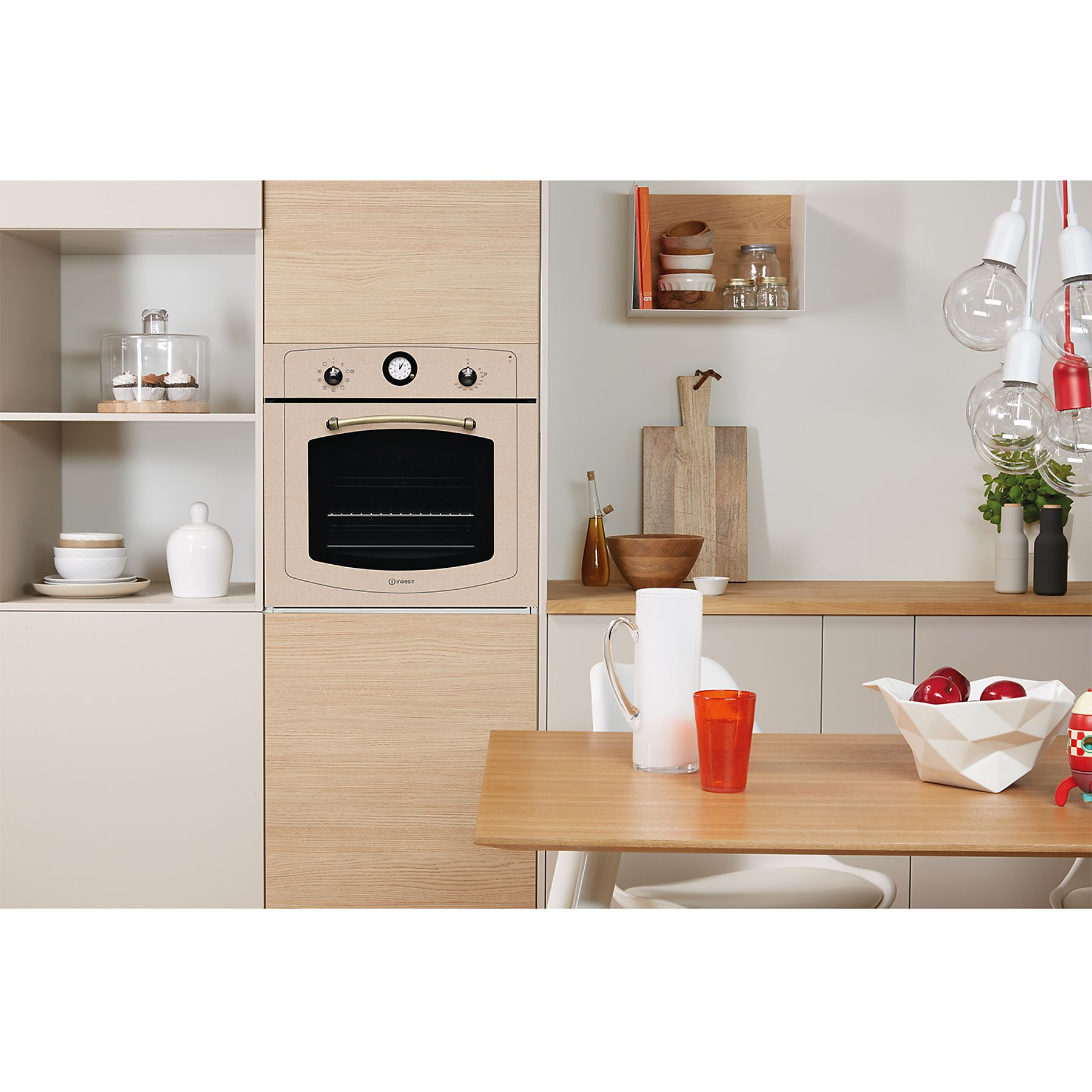 Un forno integrato in un mobile da cucina. Ha un frontale beige chiaro, con manopole e maniglia, e una porta a vetro.