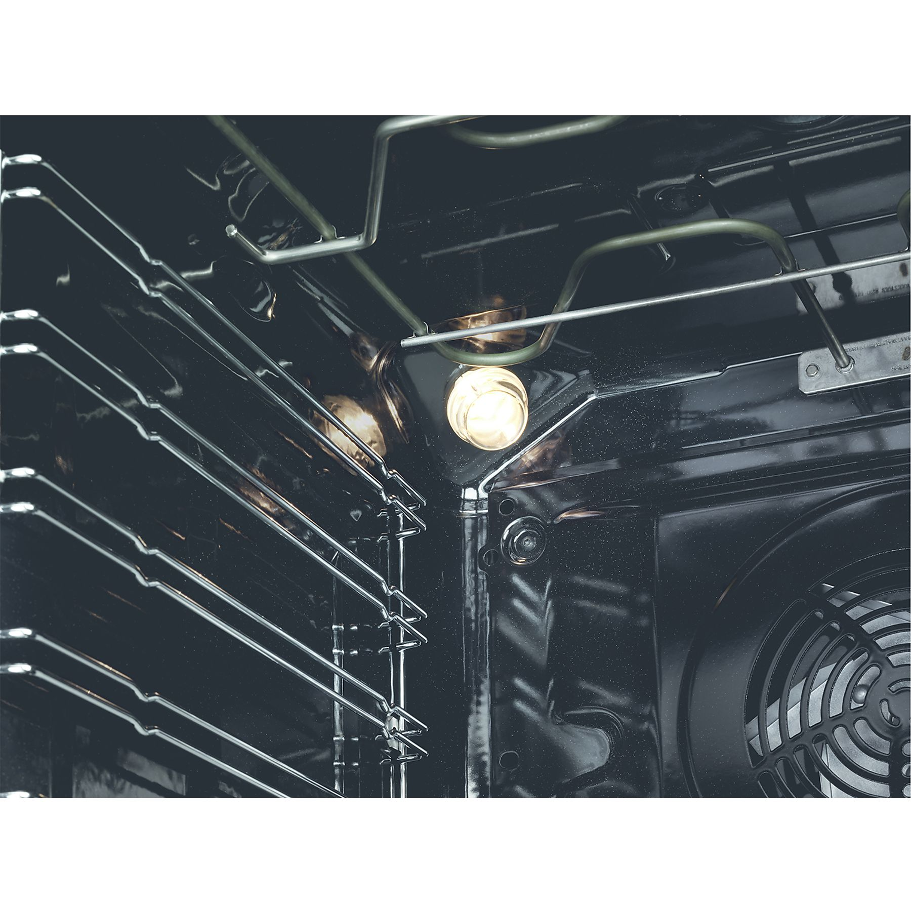 Interno di un forno, con griglie e luce. Interno scuro con elementi metallici.