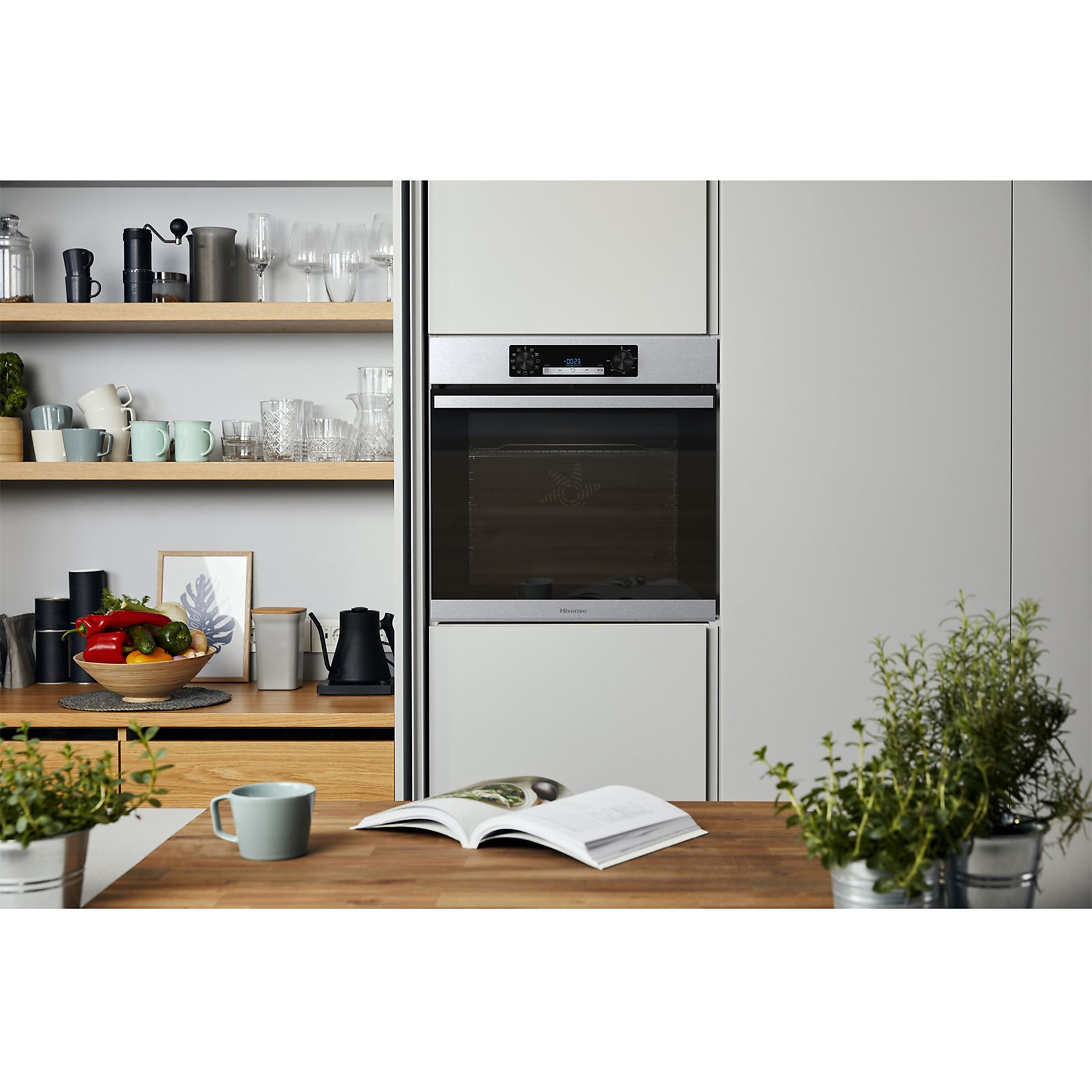Scena cucina con forno, tavolo legno, libro aperto, erbe e scaffali con utensili e cibo.
