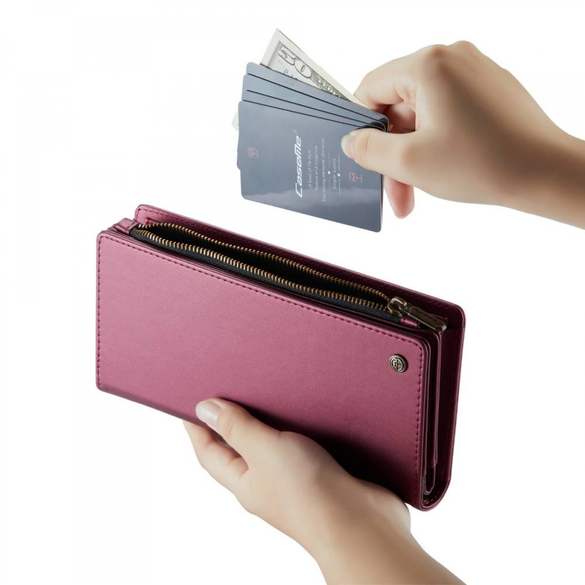 Die Hände einer Person öffnen eine rosa Geldbörse mit Bargeld und Karten darin.
