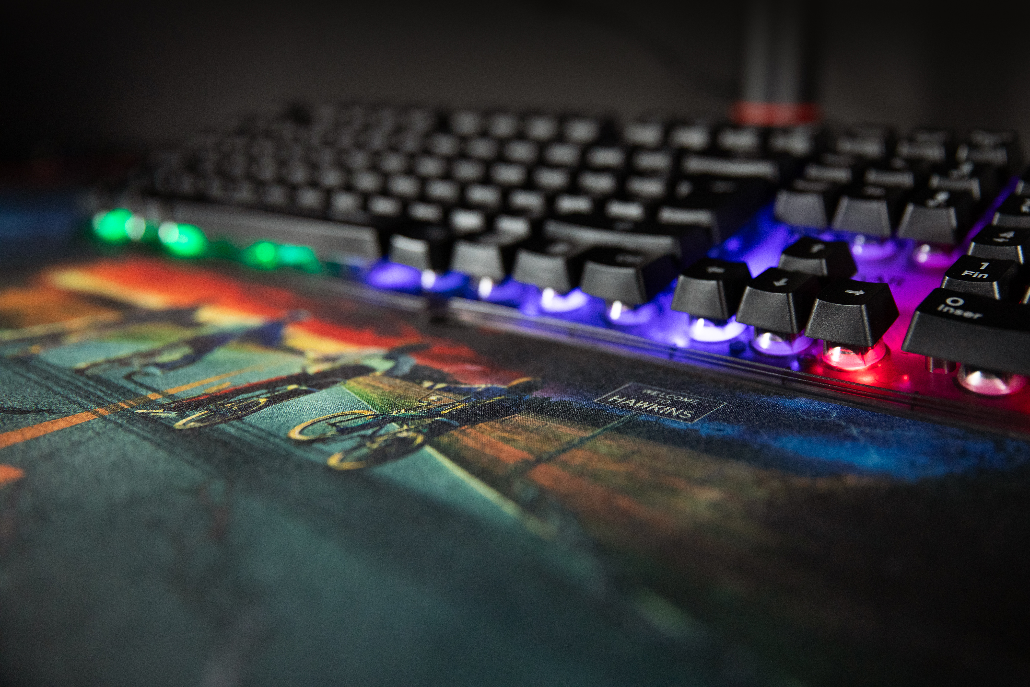 Klawiatura na podkładce pod biurko ze światłami. Tło: scena Hawkins.