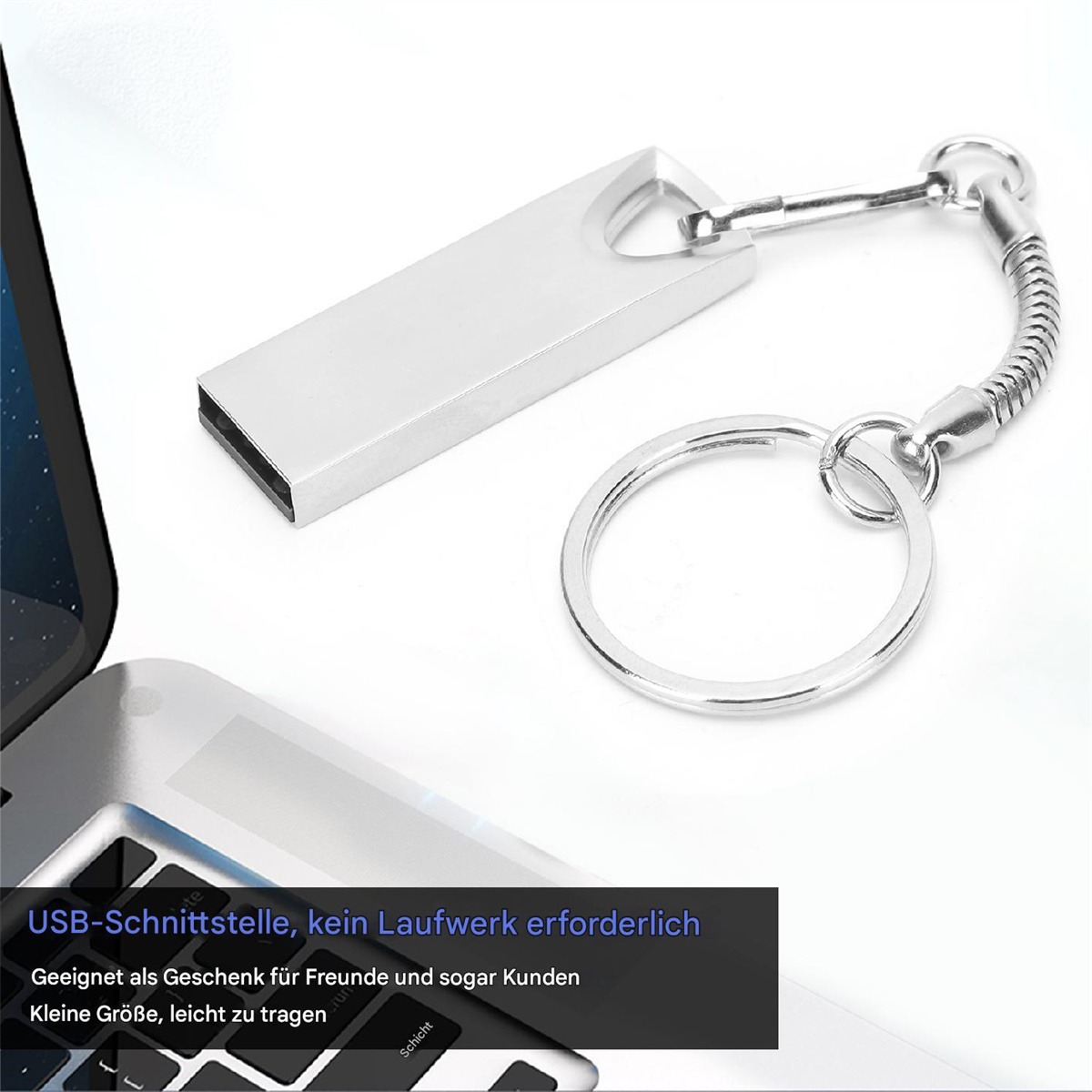 Silberner USB-Stick an einem Schlüsselanhänger. Laptop teilweise im Hintergrund sichtbar. Weißer Hintergrund.