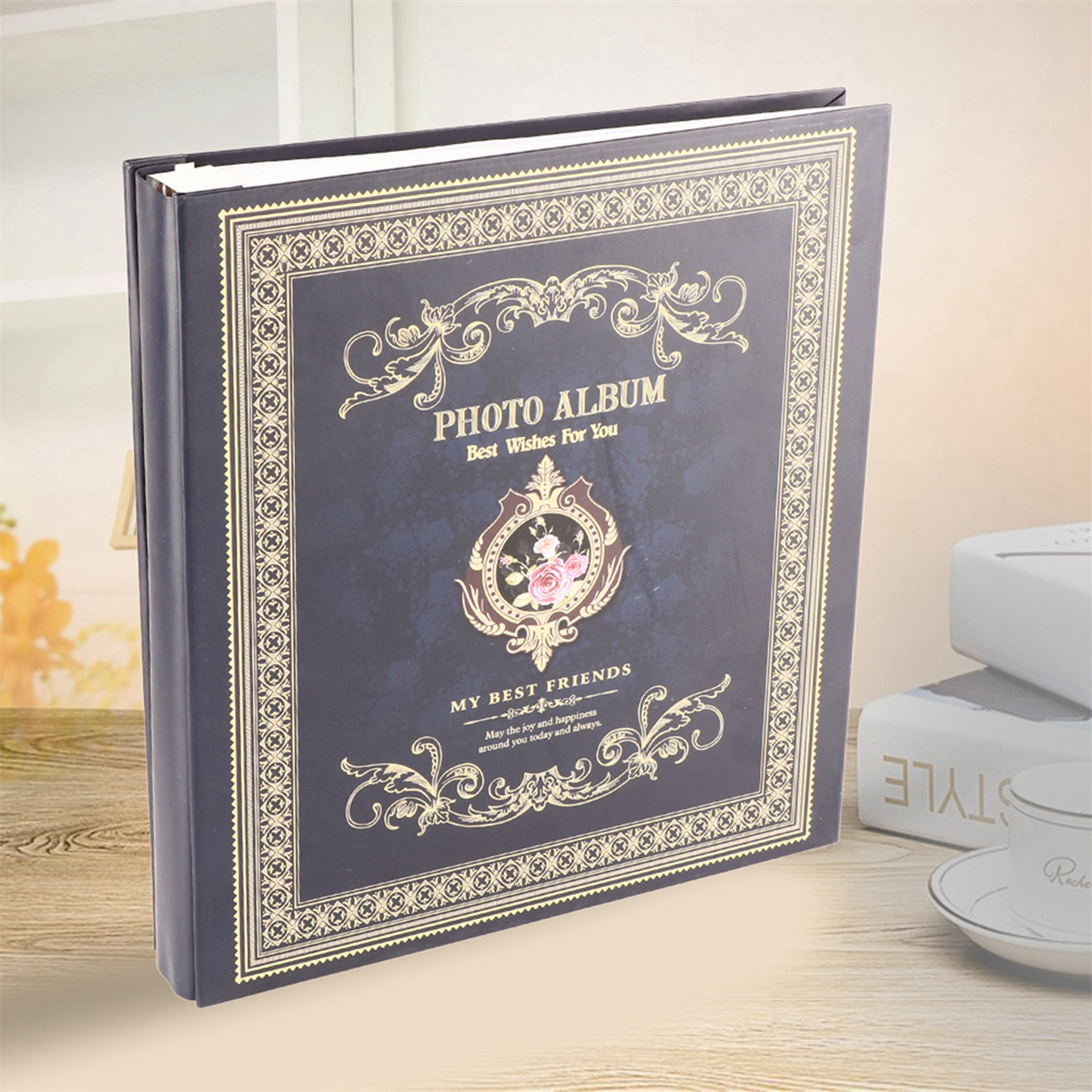 Ein Fotoalbum mit marineblauem Einband und goldenen Details. Der Einband hat ein dekoratives Design und Text.